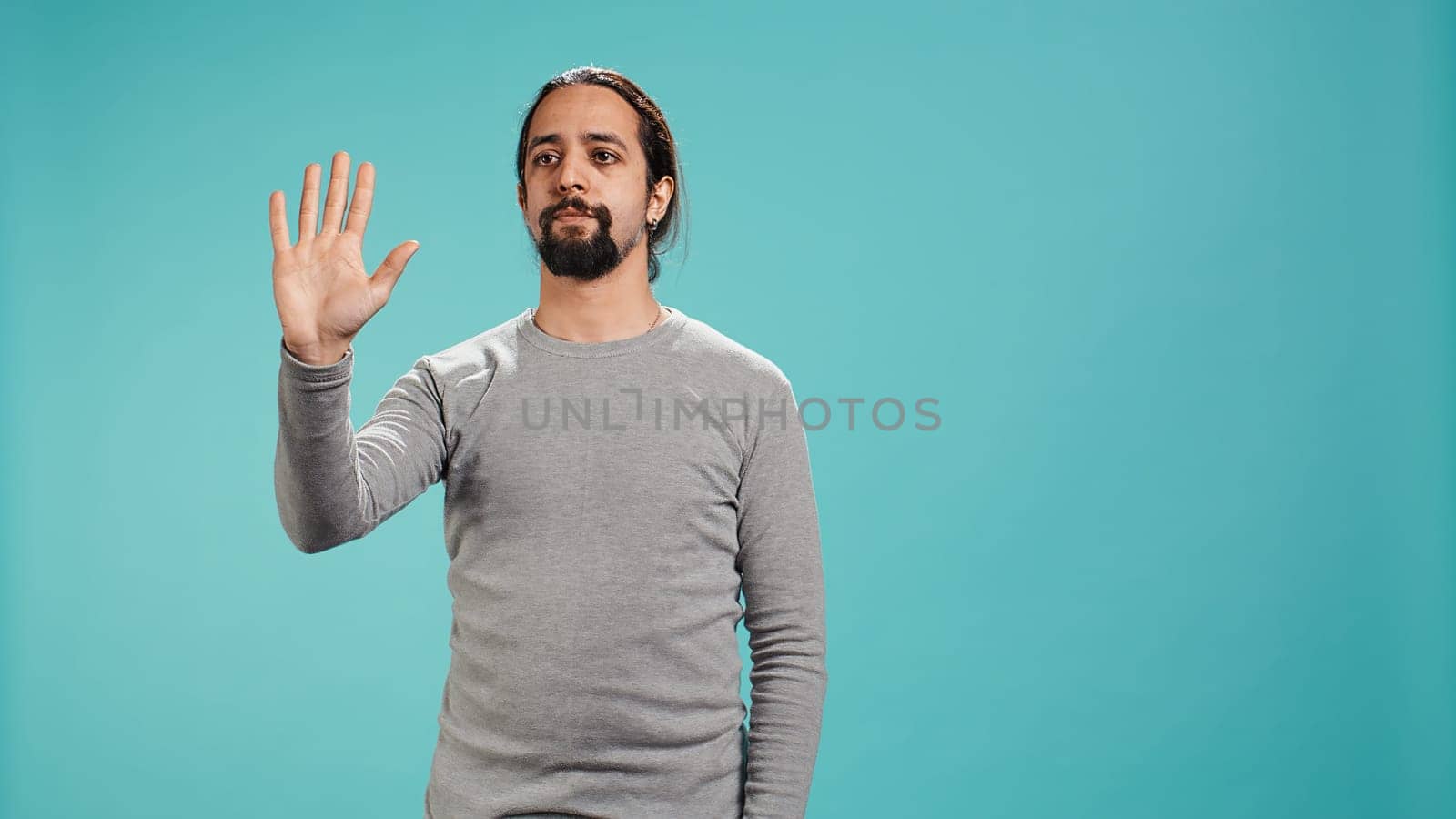 Man looking at AR hologram visualizations, doing swiping gestures. Technology enthusiast using futuristic modern augmented reality tech, isolated over studio background, camera B