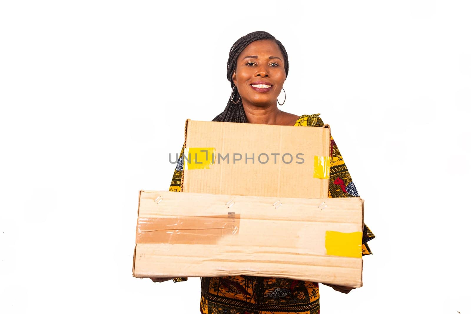 beautiful african woman standing in traditional outfit on white background smiling holding parcel.