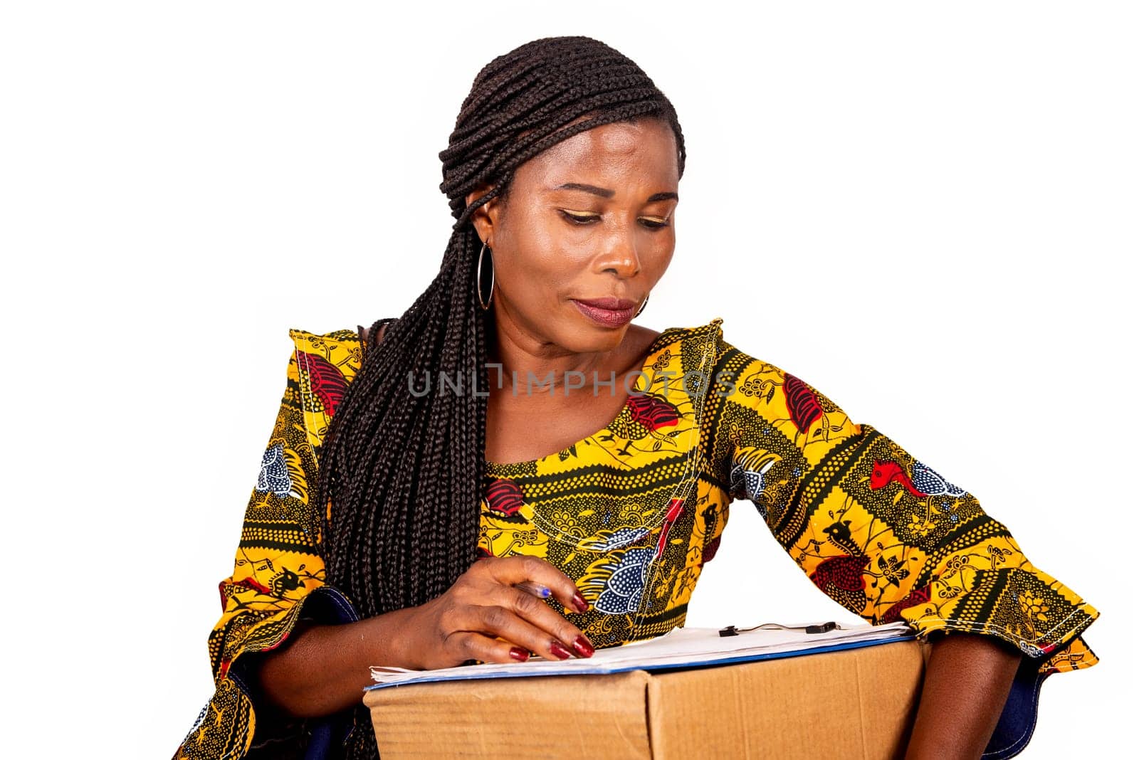 beautiful african woman standing in traditional dress on white background ready to sign a document after receiving a package.