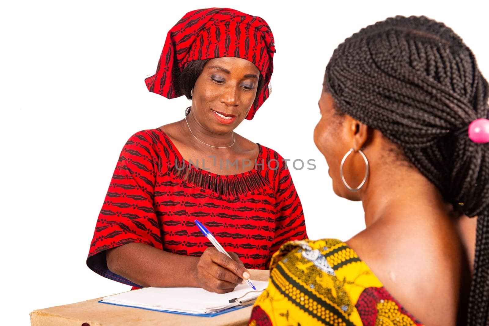 beautiful african woman standing in traditional dress on white background smiling signing a document after receiving an online package.
