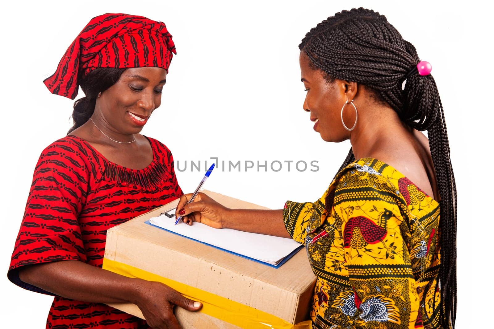 beautiful african woman standing in traditional dress on white background smiling signing a document after receiving an online package.