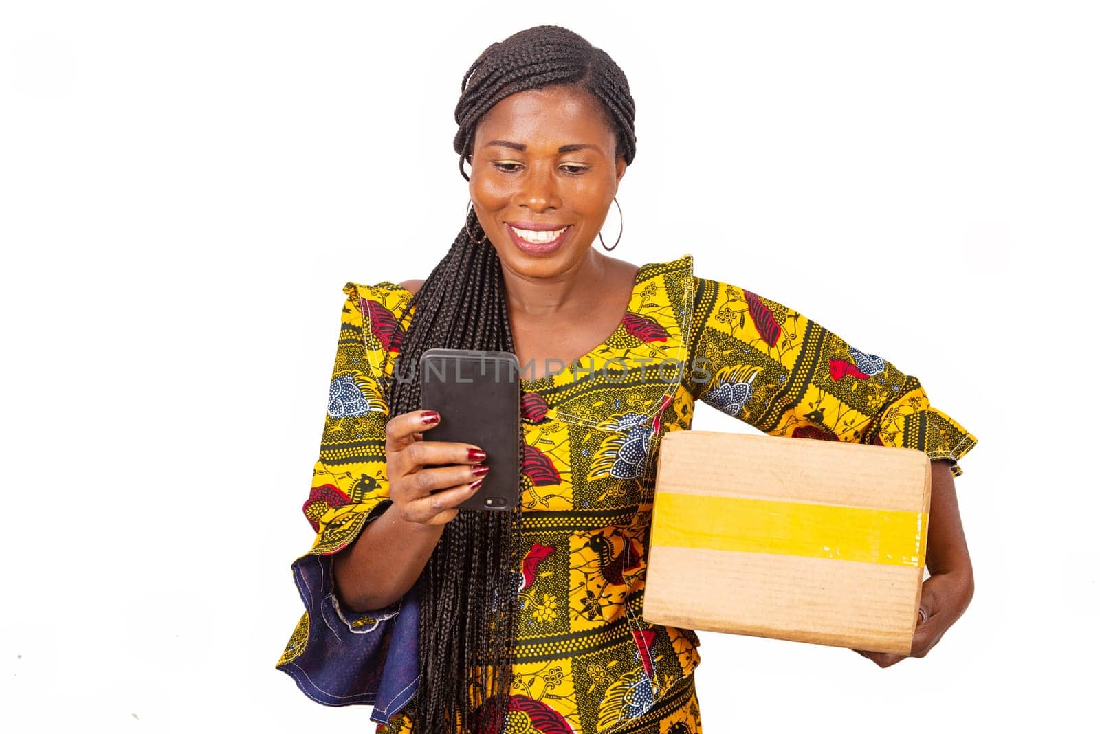 beautiful adult woman looking at the cellphone while holding a cardboard while smiling