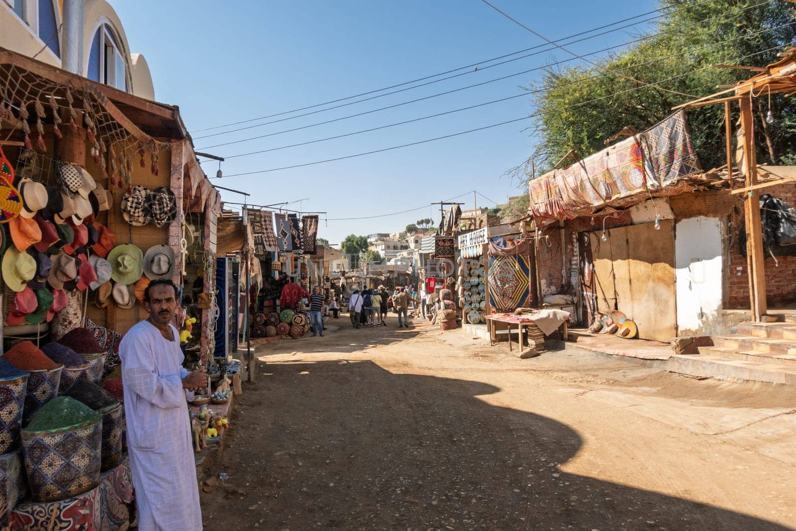 Aswan, Egypt - 5 November 2024: Traditional street market in Nubian Village with tourists in the distance
