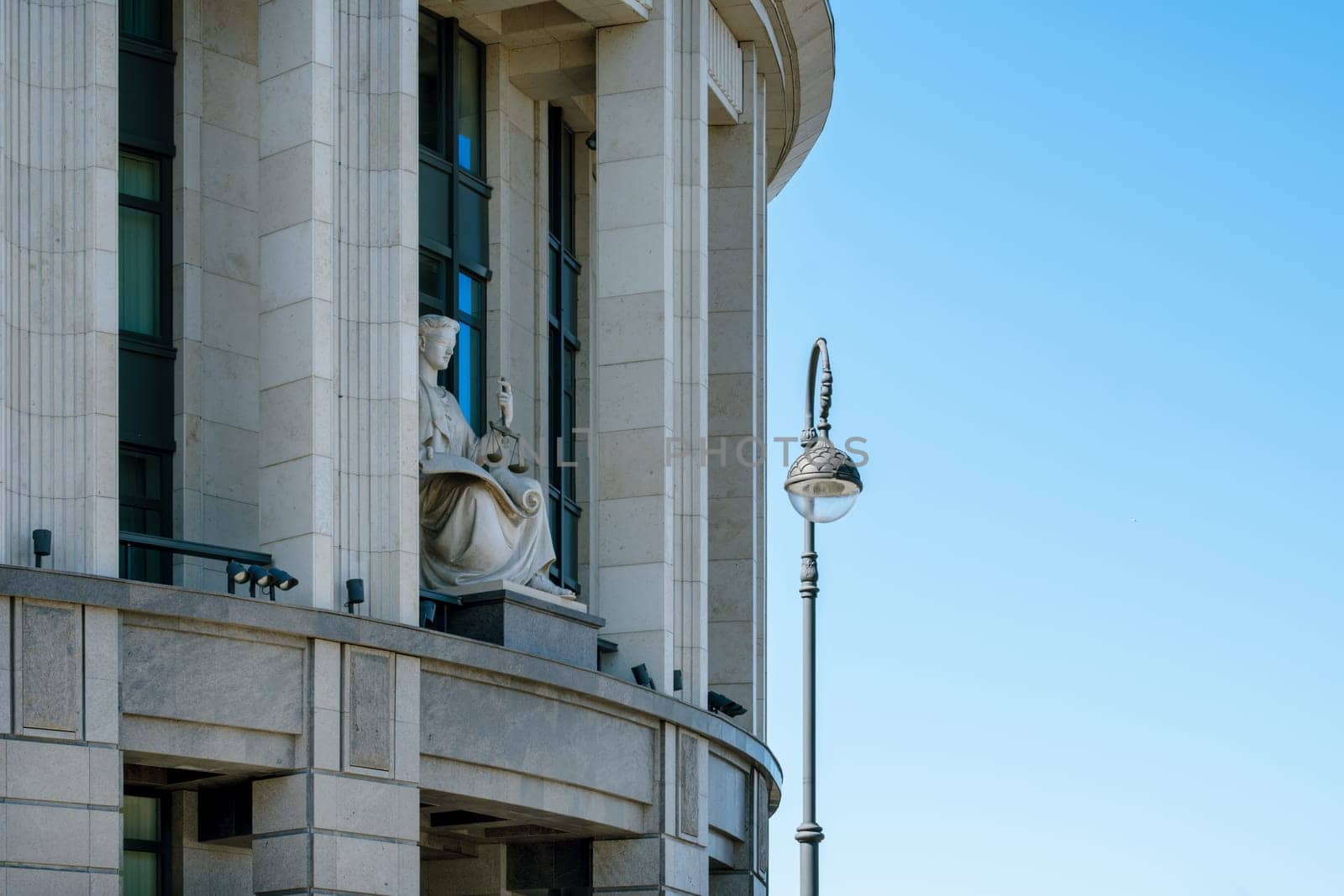 Saint-Petersburg, Russia - 05.18.24. The statue of Lady Justice in a prominent place on the facade of the Arbitration Court of St. Petersburg and the Leningrad Region under a clear blue sky