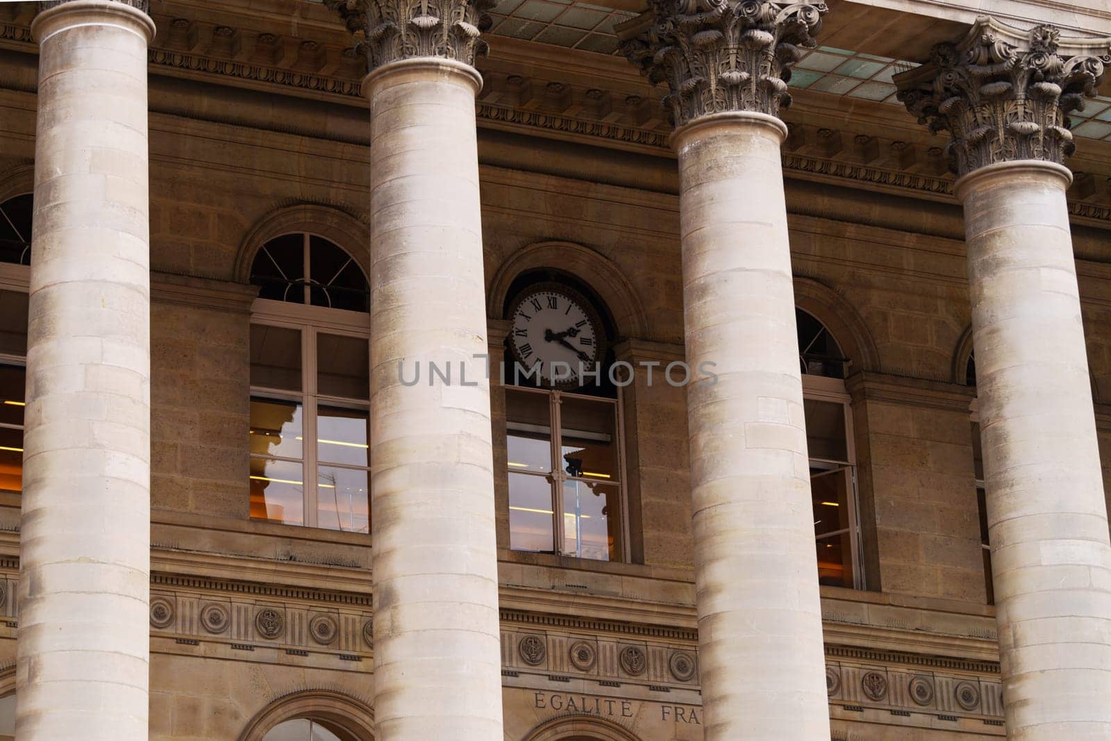 Paris, Italy - 25.01.2024: Classical architecture with columns and clock at historic building facade.