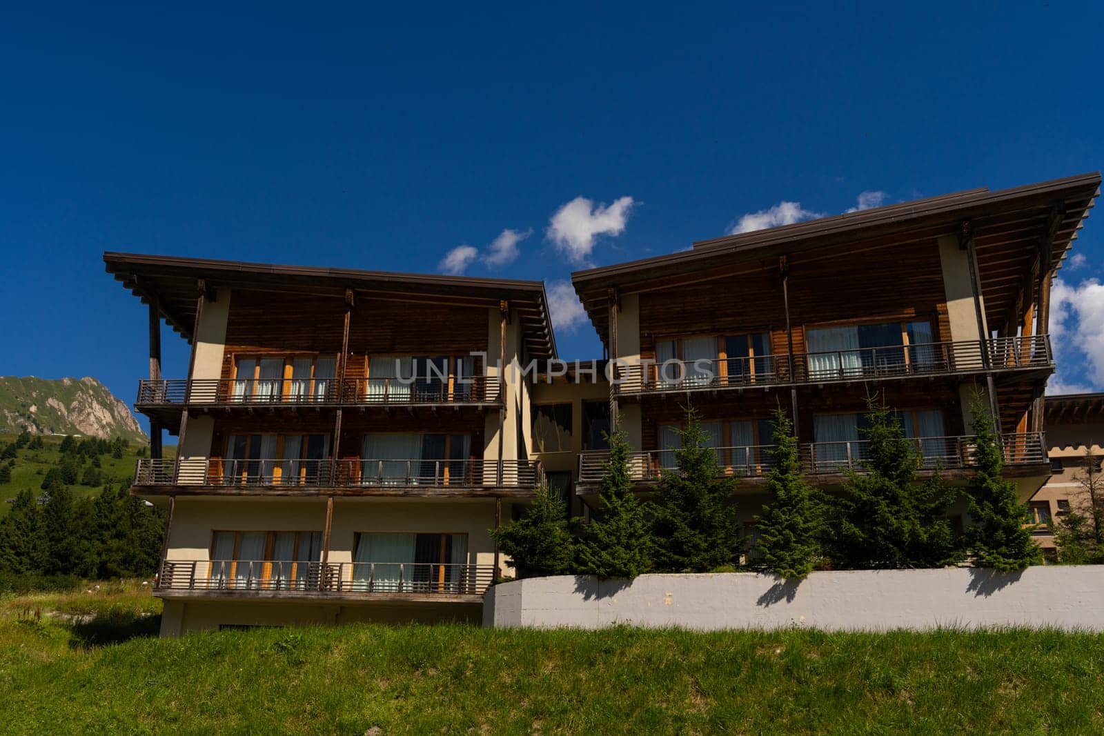 Passo Tonale, Italy - 10.08.2024: Modern mountain chalet with scenic view and blue sky.