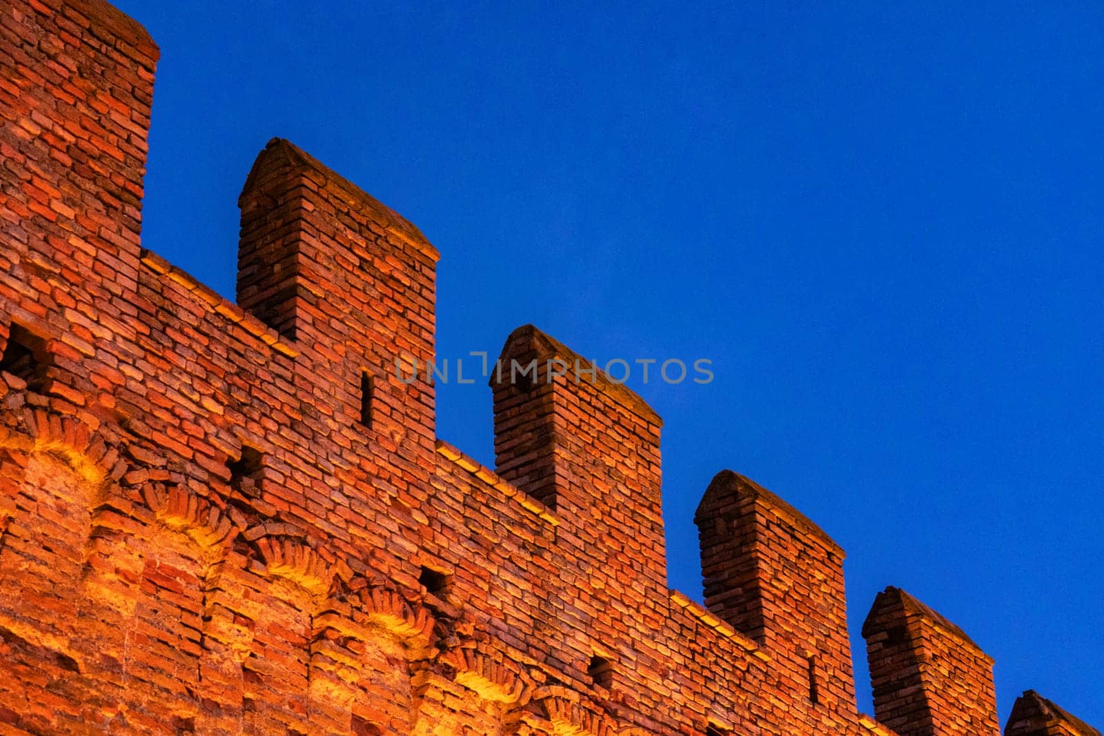 Gradara, Italy - August, 25, 2022: illuminated gradara castle walls with vibrant dusk sky
