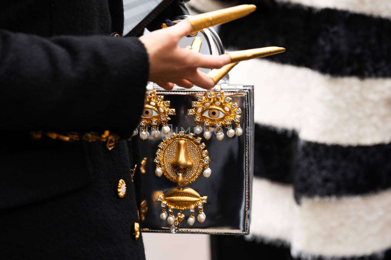 Paris, France - January, 22, 2024: woman wears embroidered jewelry Schiaparelli bag, fashion blogger outfit details, street style