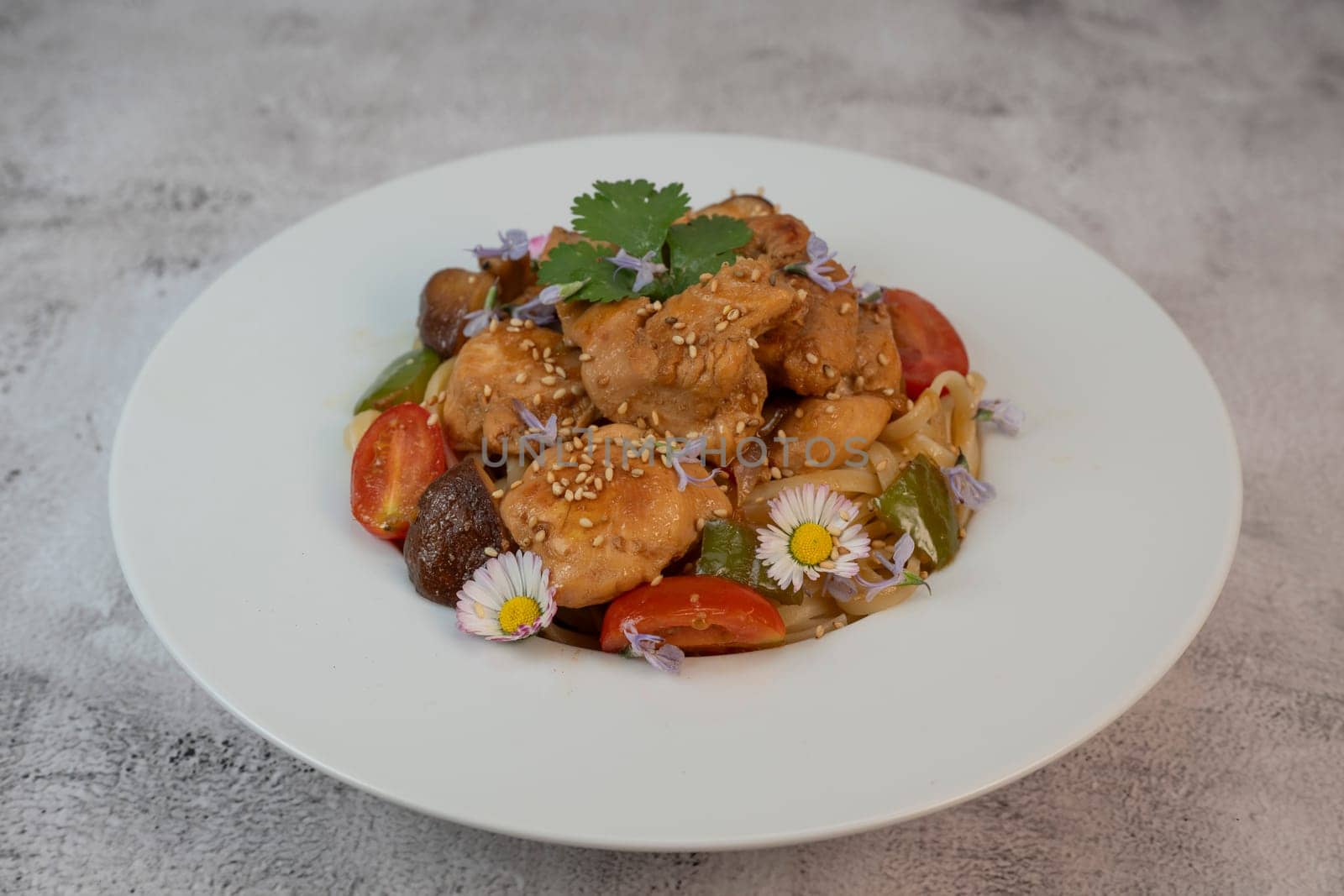A flavorful blend of chicken, linguine, shiitake mushrooms, bell peppers, and fresh garden flowers offers a vibrant and appetizing meal. Ideal for a cozy dinner or gathering.