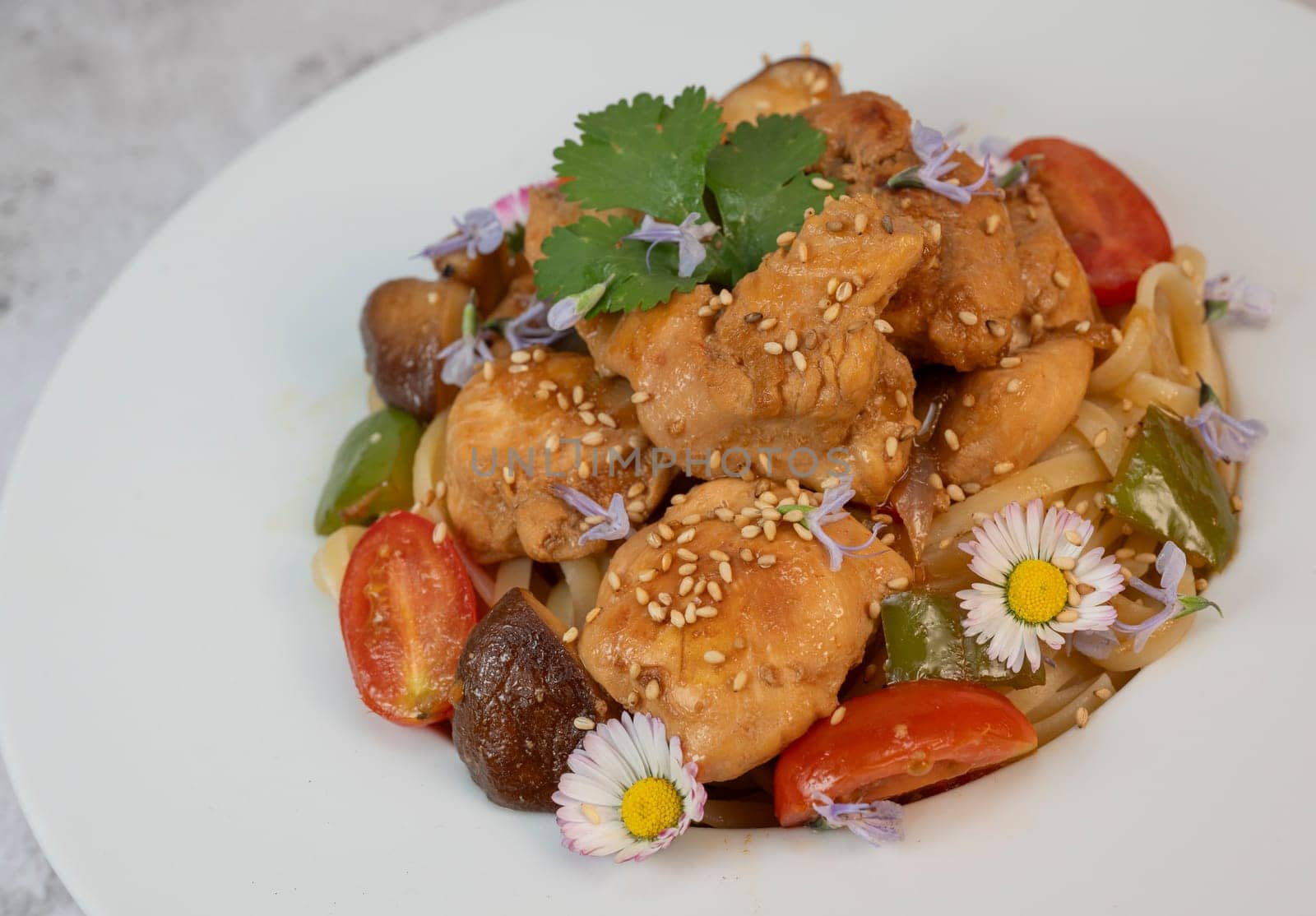 A flavorful blend of chicken, linguine, shiitake mushrooms, bell peppers, and fresh garden flowers offers a vibrant and appetizing meal. Ideal for a cozy dinner or gathering.