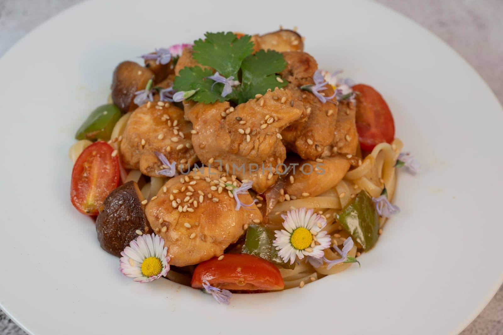 A flavorful blend of chicken, linguine, shiitake mushrooms, bell peppers, and fresh garden flowers offers a vibrant and appetizing meal. Ideal for a cozy dinner or gathering.