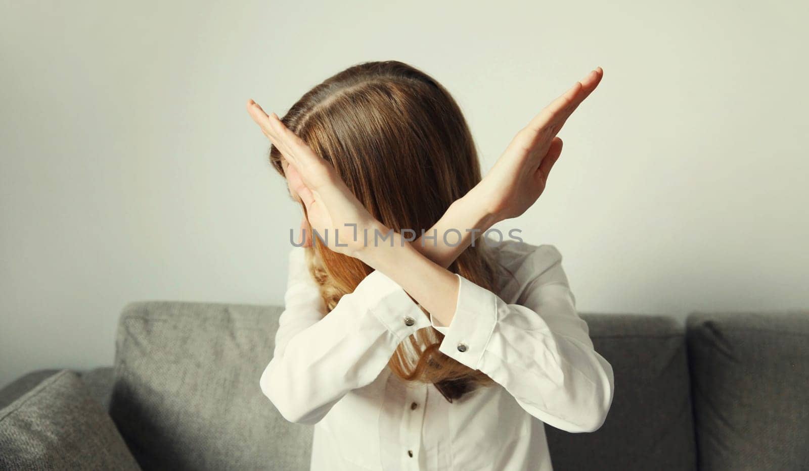 Close-up upset young woman shows stop, no or enough sign with palm of hand, refusal gesture, domestic violence