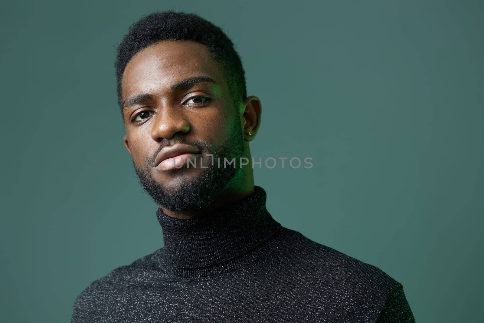 Thoughtful man in a turtleneck sweater gazes sideways with a serious expression, lost in deep contemplation.