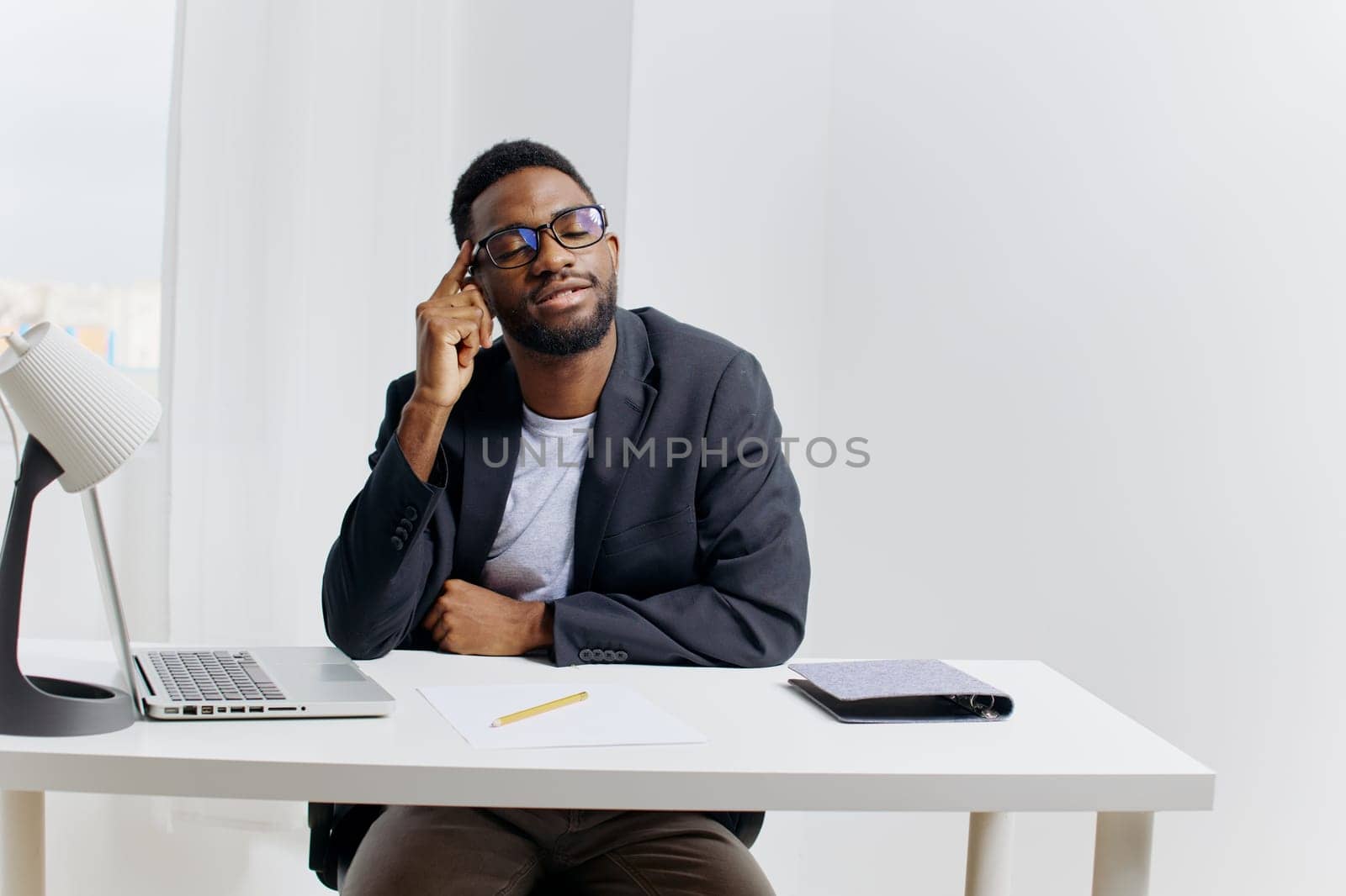 Business professional working on a laptop while speaking on the phone at an office desk, focused on managing tasks and communication.