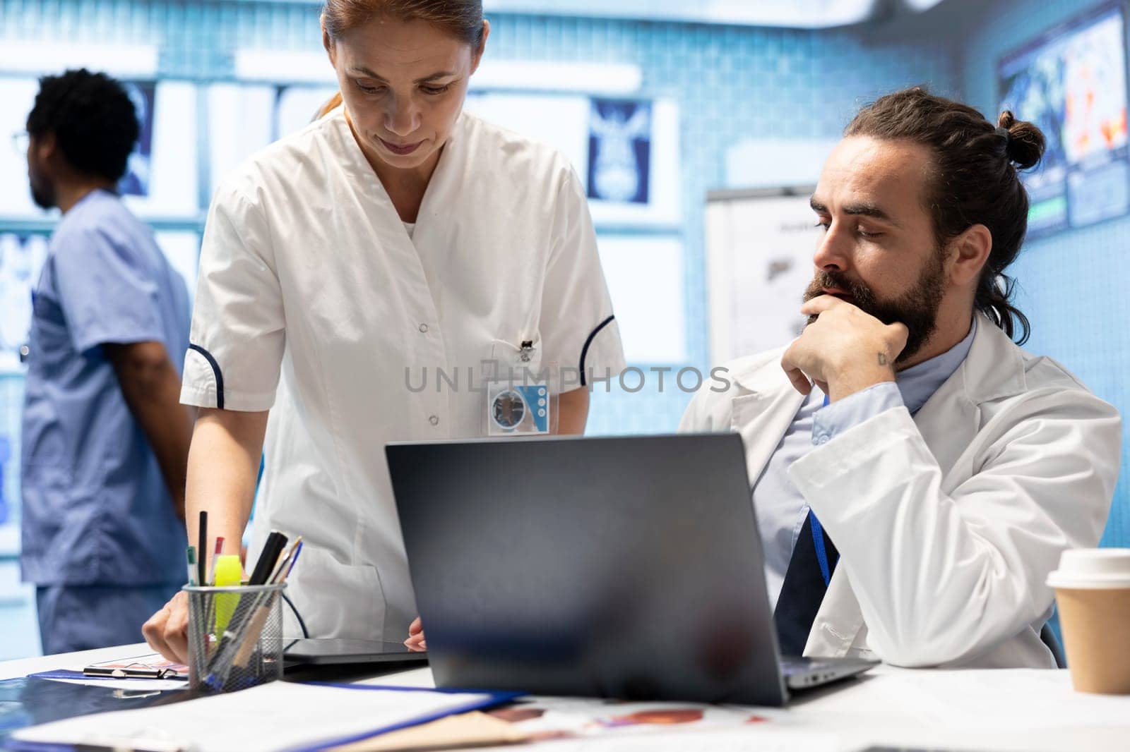 Medical staff collaborates on diagnostic procedures and treatment plans. Radiology specialists work on accurate diagnosis and effective disease prevention, healthcare industry insurance.