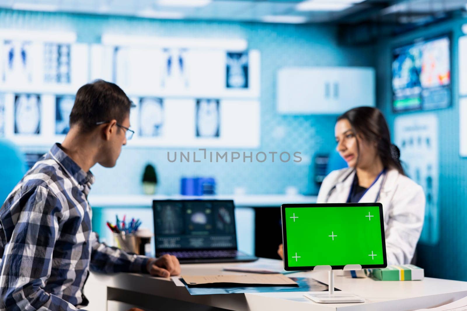 Specialist discussing x ray imaging with a patient next to isolated mockup display, presenting healthcare diagnosis during check up visit. Physician sharing the treatment plan and advice.
