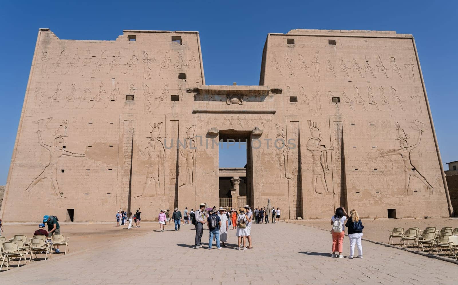 Edfu, Egypt - 6 November 2024: Many tourists looking at the facade of the massive temple in Edfu dedicated to Horus and Hathor