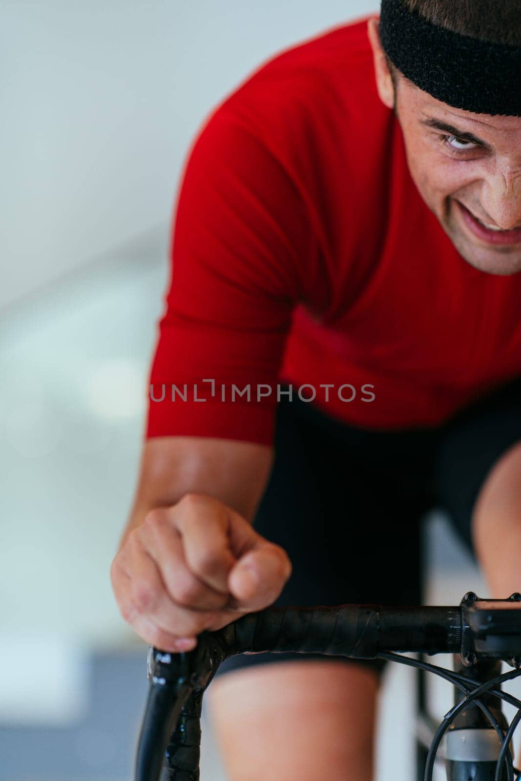 A triathlete riding a triathlon bike on a machine simulation in a modern living room. Training during pandemic conditions