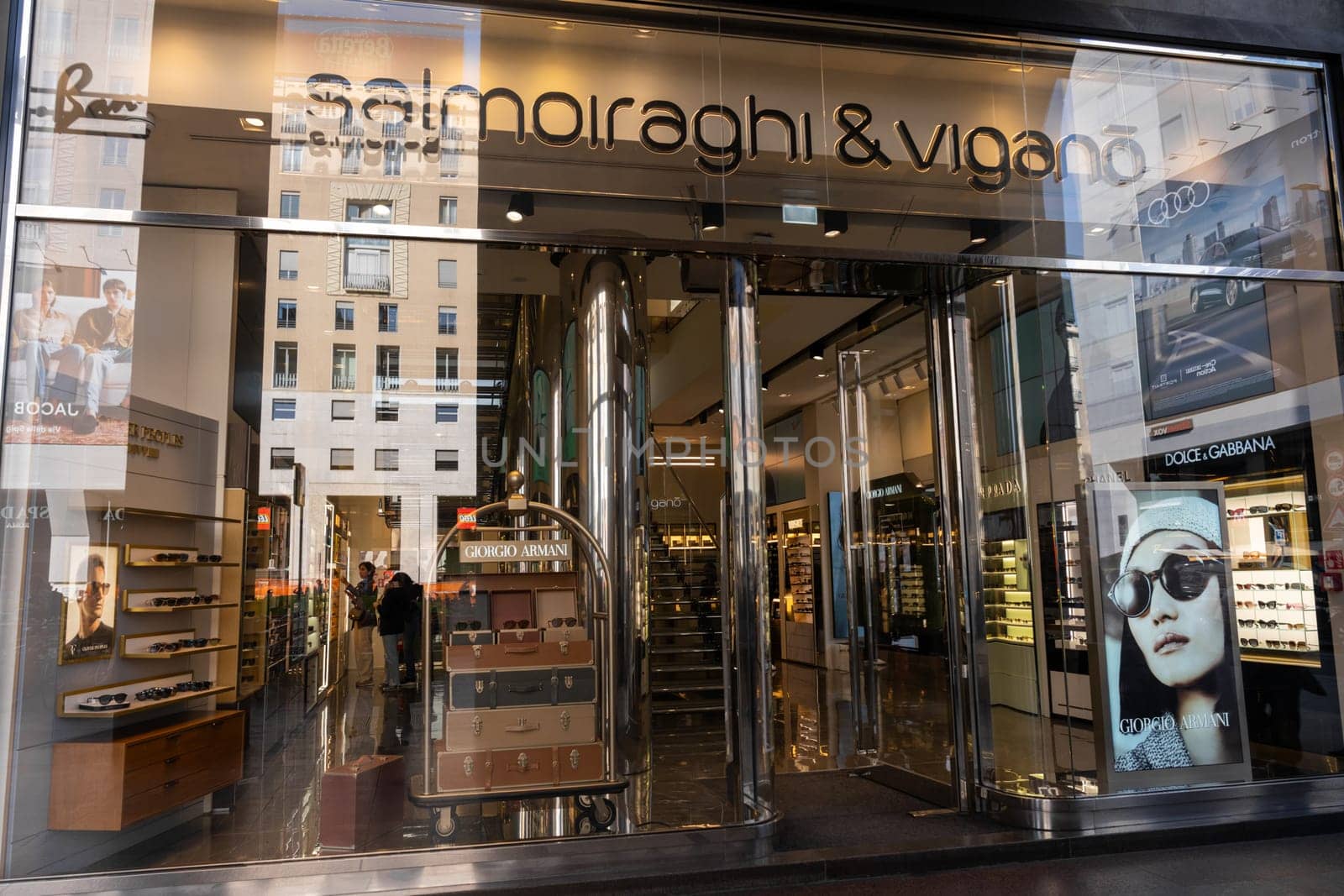 Milan, Italy - April, 08, 2025: Salmoiraghi and Vigano eyewear store exterior. Sunglass displays, Giorgio Armani poster, glass facade. Milan street view.