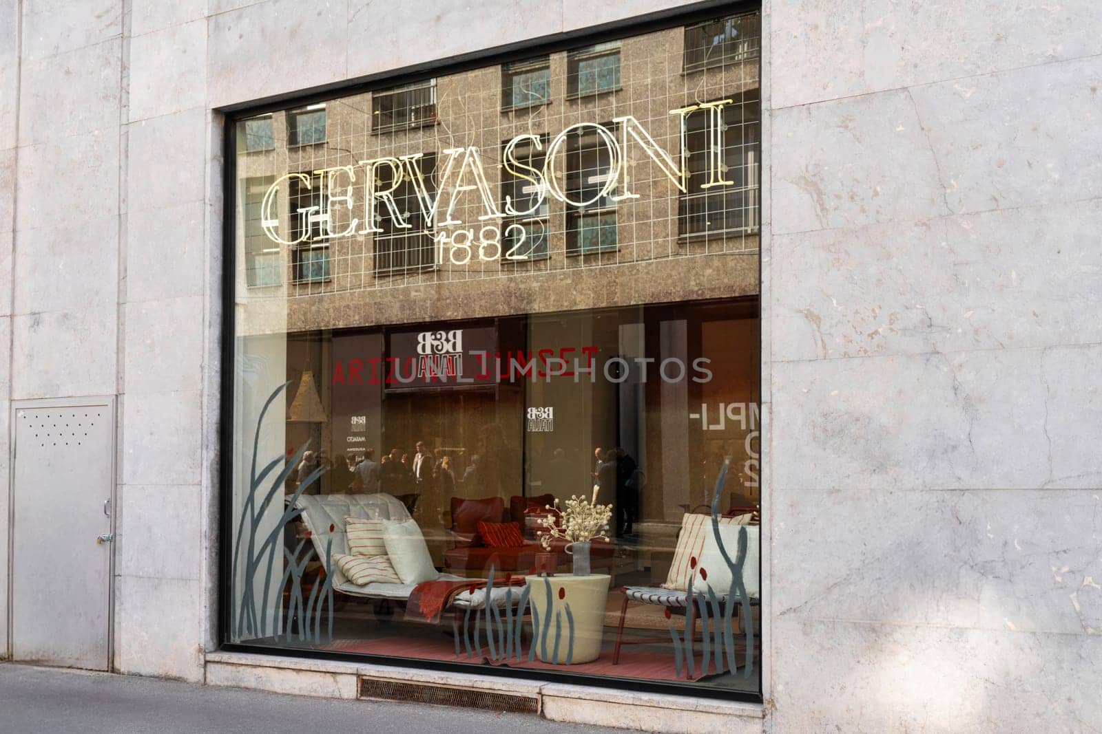 Milan, Italy - April, 08, 2025: Gervasoni 1882 showroom window display during Milan Design Week 2025. Arizona Sunset interior furniture theme visible.