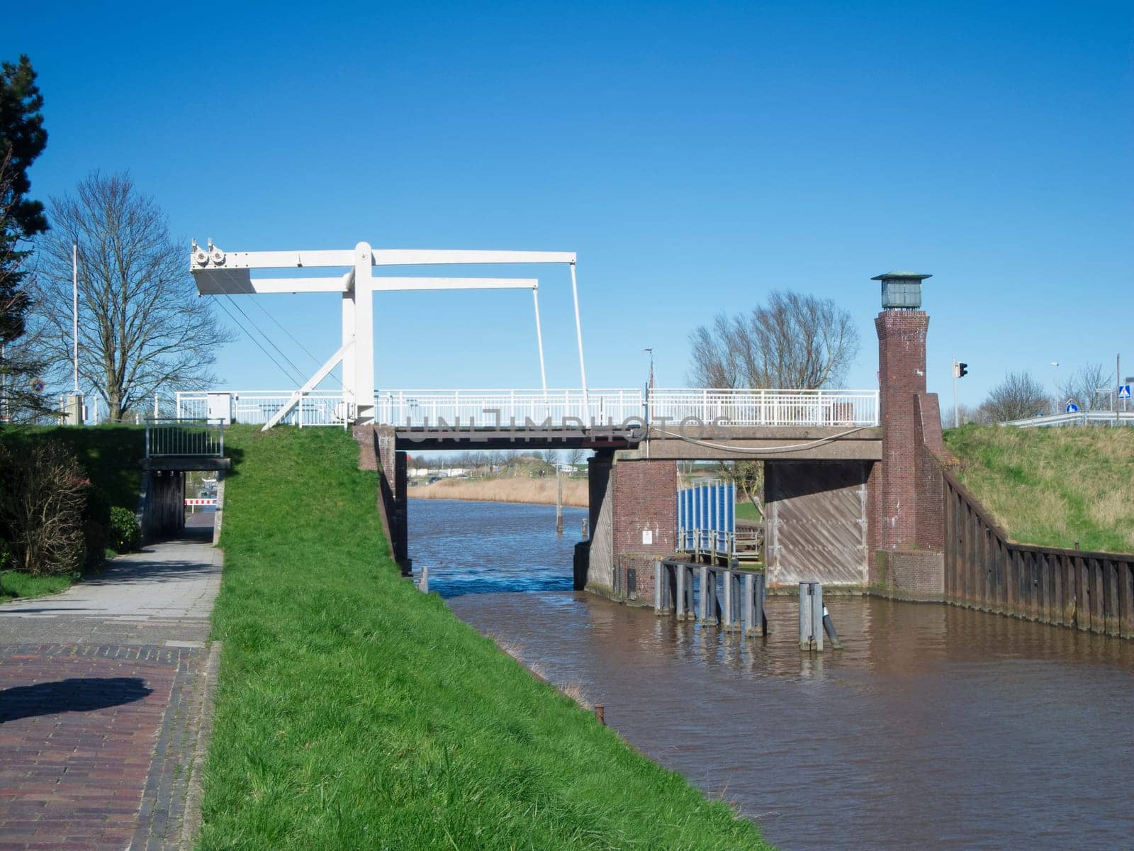 View of the former Sielschleuse on the Harle, today's Friedrichsschleuse, built in 1765 between Harlesiel and Carolinensiel, with a bascule bridge in East Frisia, Lower Saxony, against a blue sky.