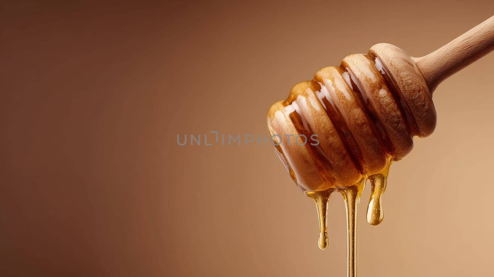 Honey dipper with golden liquid honey against a brown background.