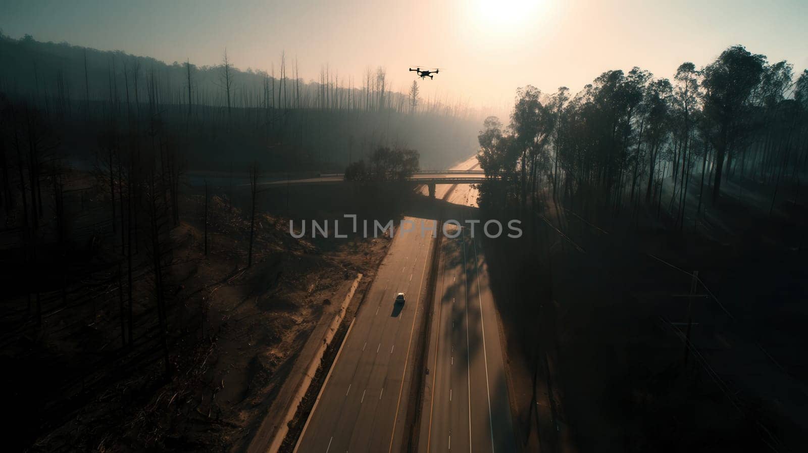 Surveillance drone hovers above a lonely highway through a wildfire-scorched forest at sunrise. A powerful visual for climate change, technology, or emergency response themes