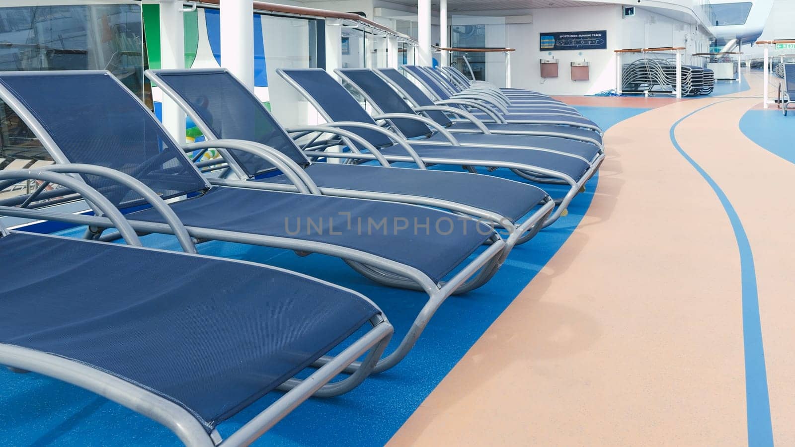 A serene view of blue deck chairs perfectly arranged in neat rows on a luxurious cruise ship deck. New York NY USA - 09.02.2024.