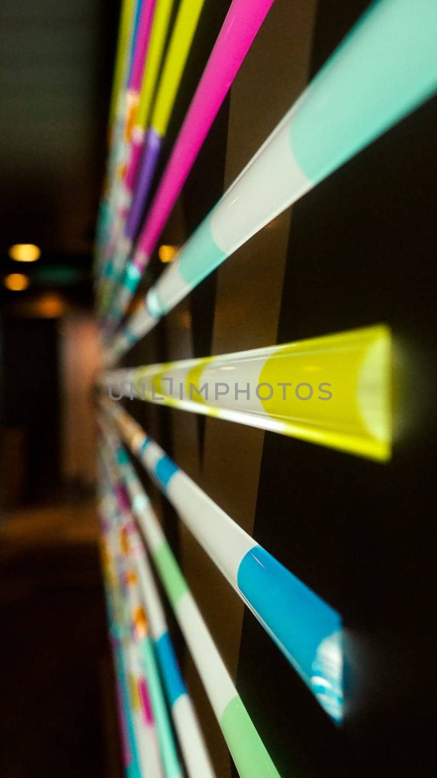 A Captivating Array of Multicolored Light Tubes Arranged Horizontally on a Solid Black Background.