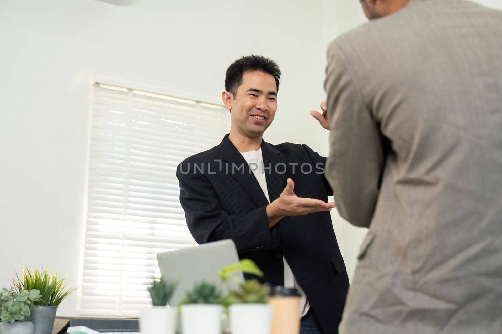 In a contemporary office, two professionals communicate effectively, discussing strategies and ideas for their project, emphasizing teamwork.