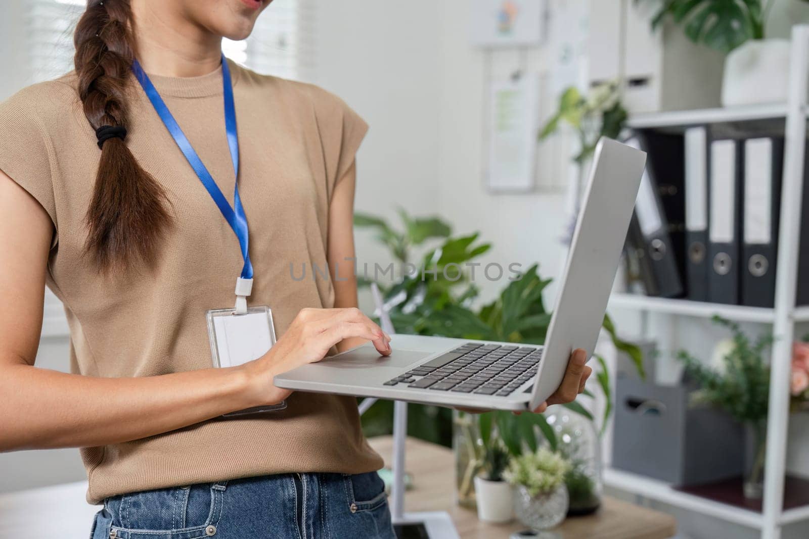 A professional woman utilizing her laptop to promote ESG sustainability initiatives in a green-focused work environment, symbolizing progress and commitment.