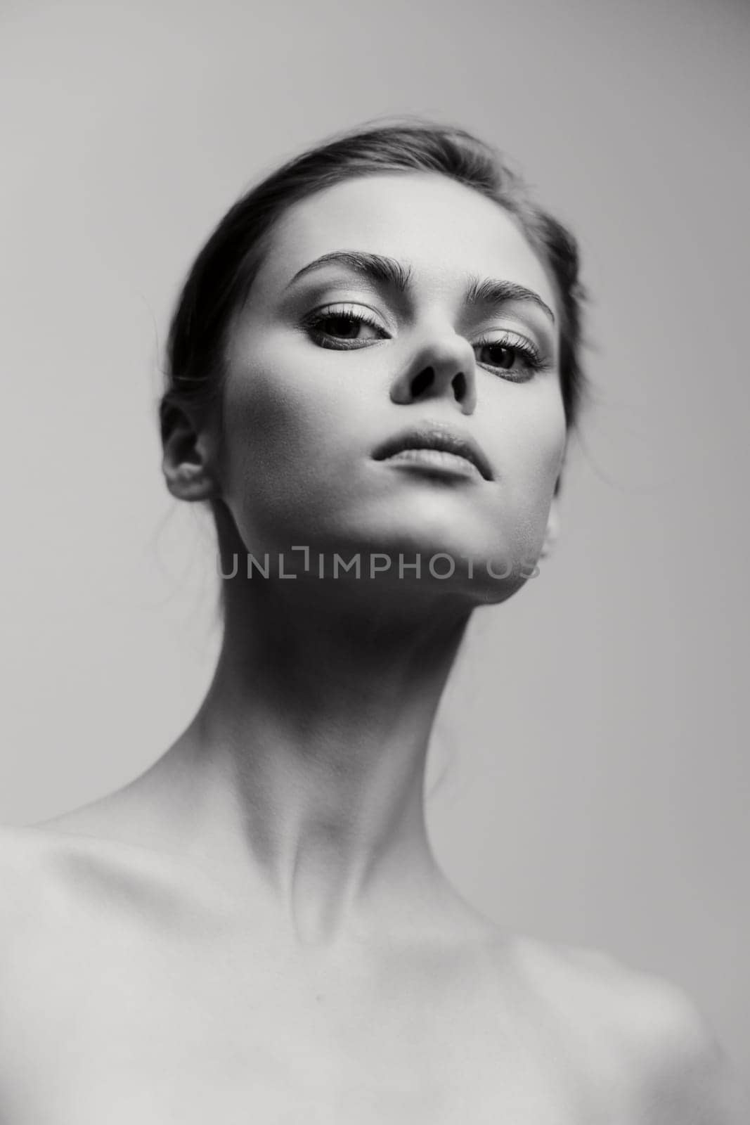Portrait of a self-assured young model with a graceful demeanor, emphasizing facial features and expressions in black and white, highlighting elegance and sophistication.