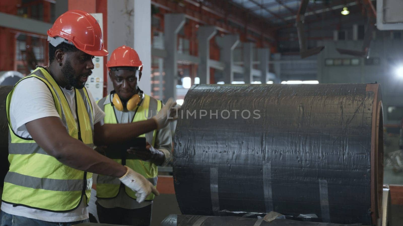 Engineer two worker man African black marking inspection on roll metal sheet before shipment in warehouse of Metal Sheet factory, Physical inventory count, checking stock industry