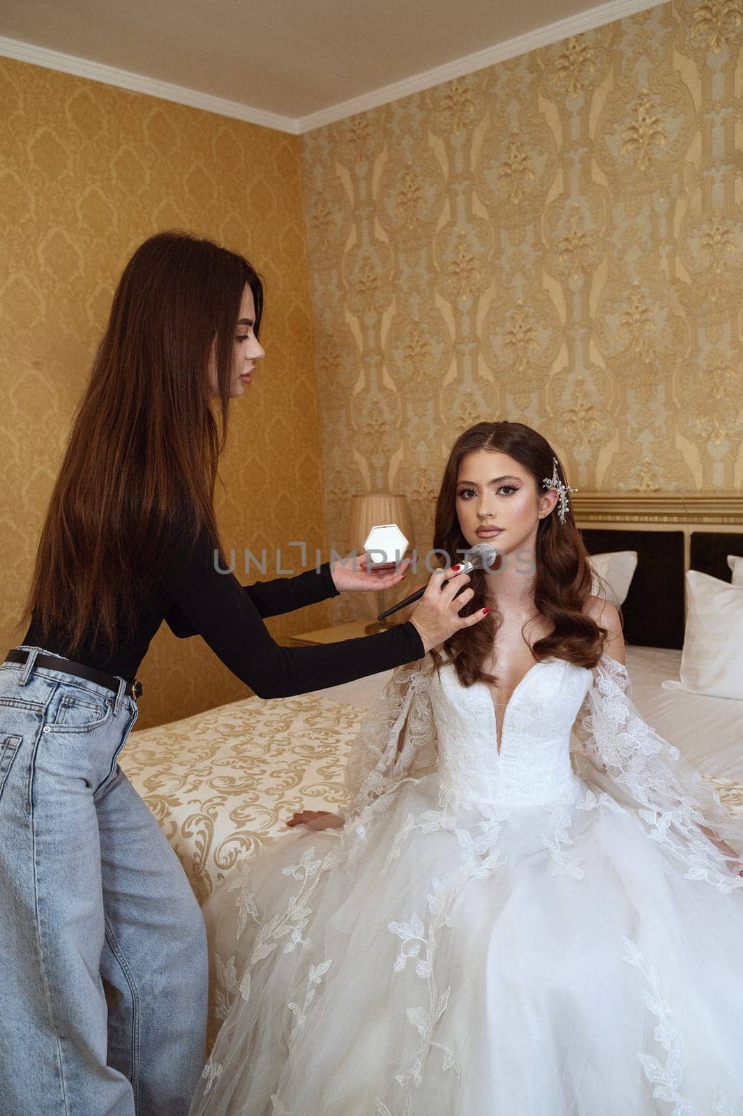 Elegant bride getting final makeup touch on her wedding day. A stunning bride getting her makeup done for a flawless wedding look. A beautiful bride getting the final touches for her special day.