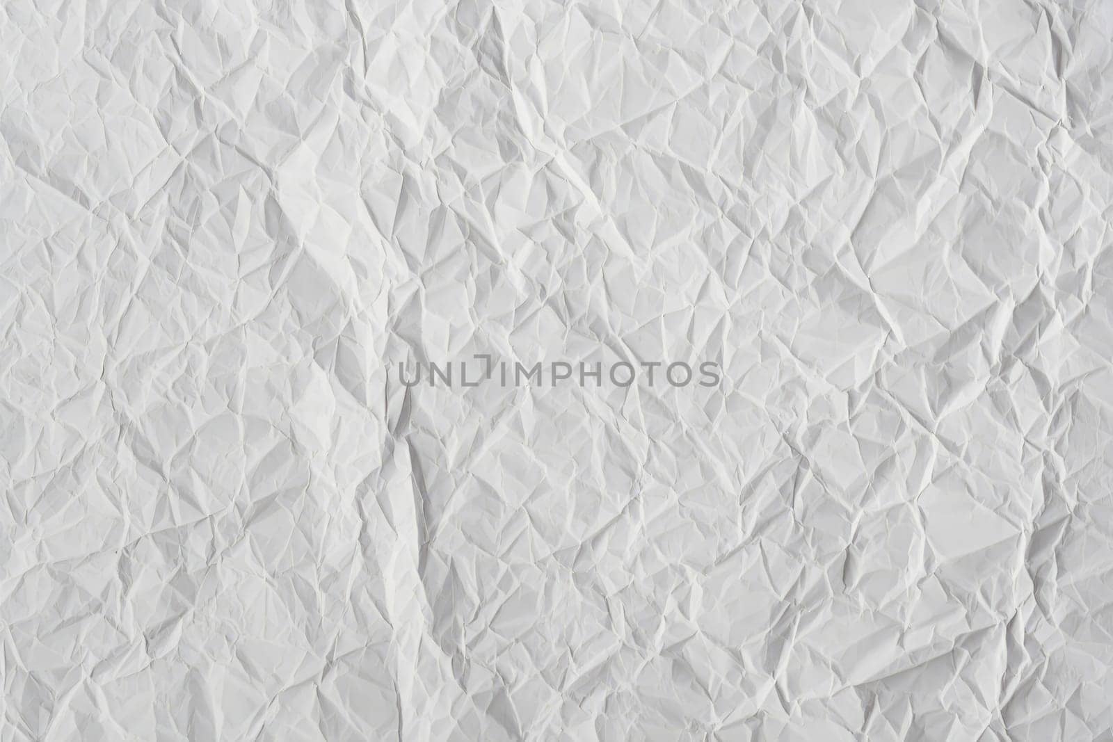 Textured crumpled white paper fills the frame, displaying a variety of intricate folds and creases. This material can be used for backgrounds in crafts or designs, adding depth and character.