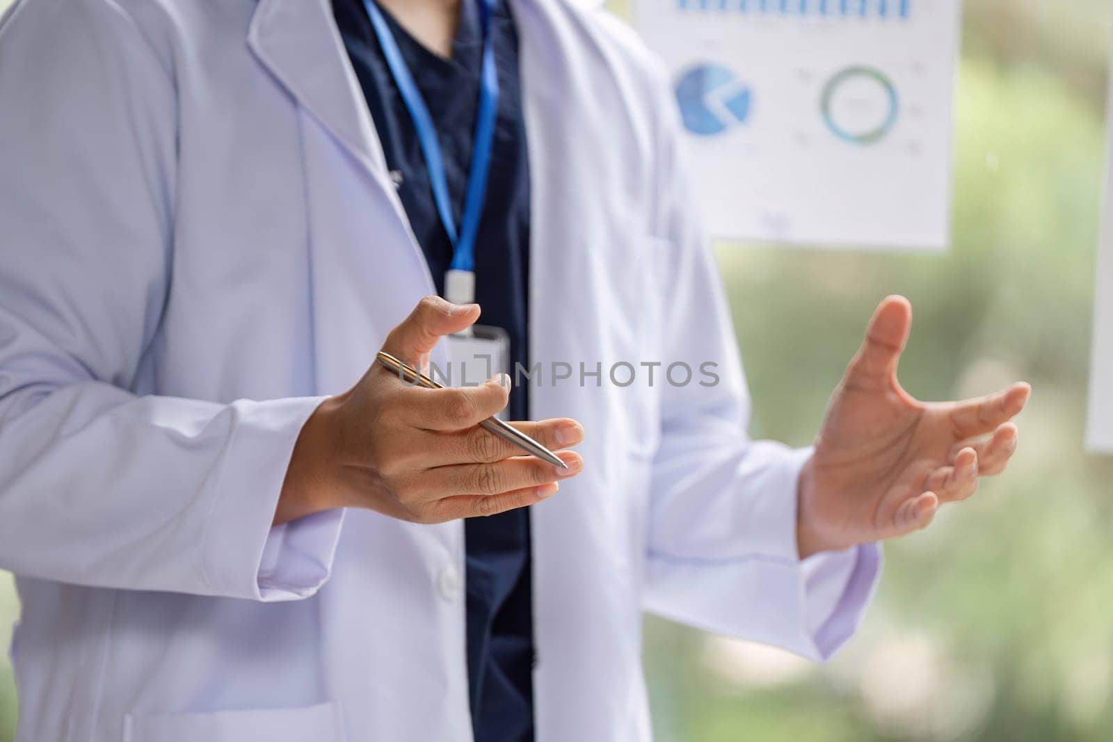 A doctor using hand movements to emphasize key points about medical data during a presentation to engage listeners.