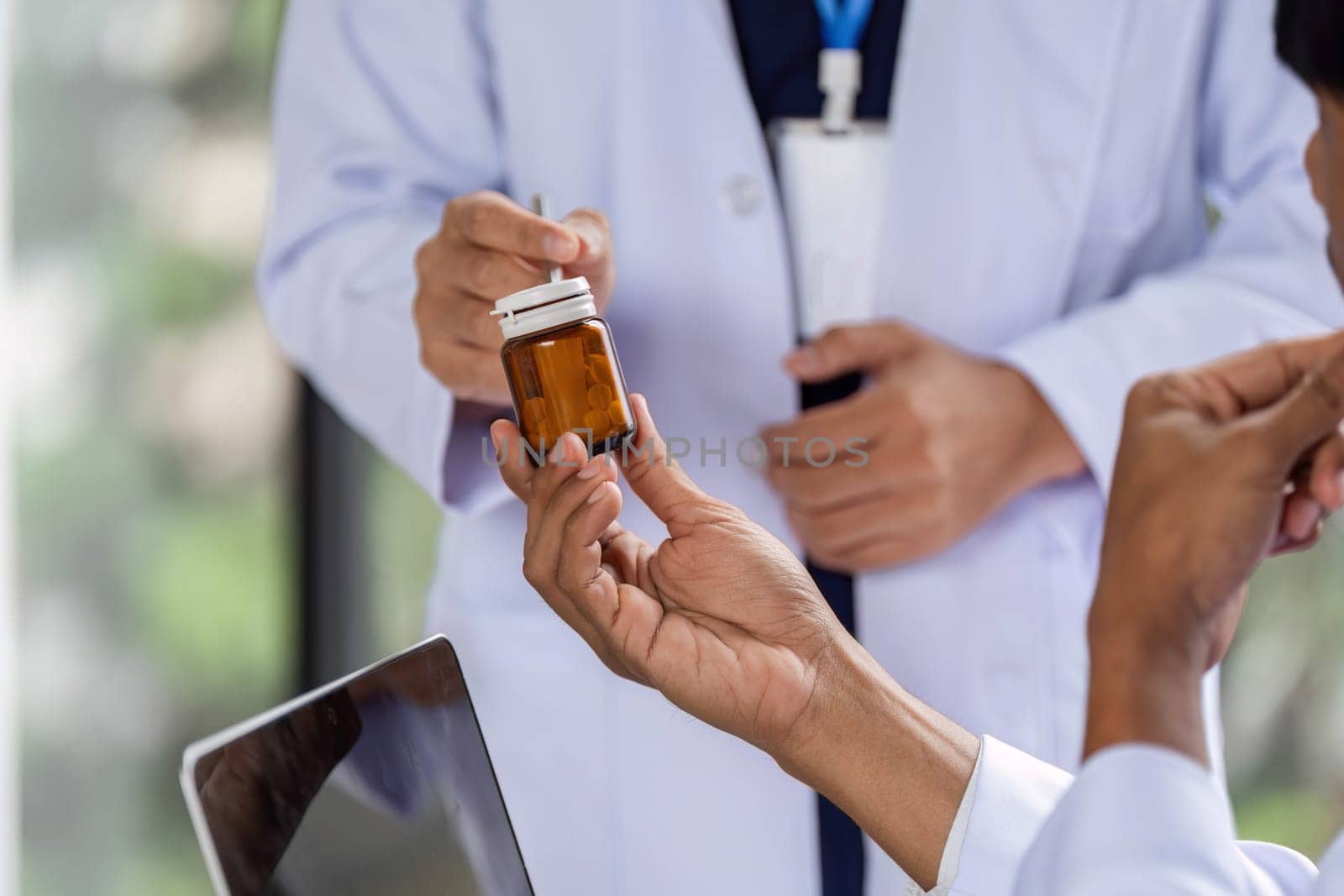 A doctor passing a prescription bottle to a colleague, enhancing collaboration for patient care and medication management.