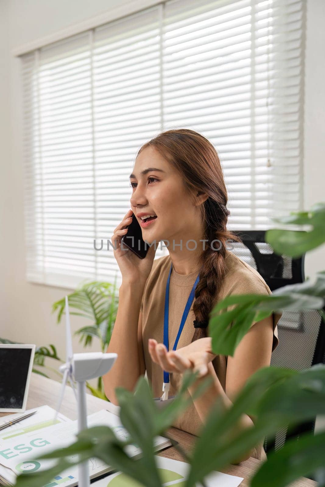 An individual engages in a phone discussion about ESG sustainability concepts, showing enthusiasm for environmental and social responsibility.