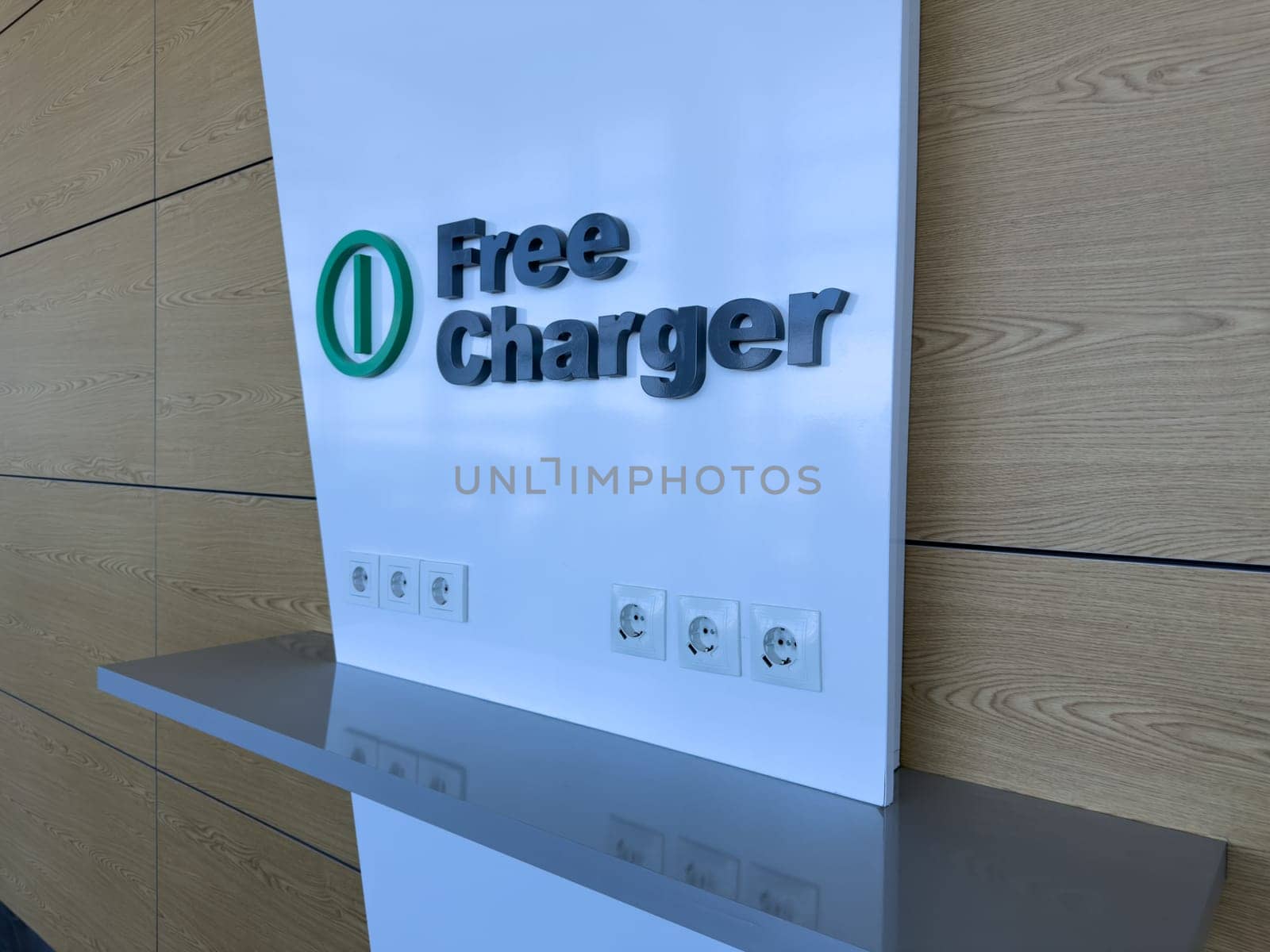 Free charging area with multiple power outlets and USB ports on clean white wall, offering modern solution for charging electronic devices in public indoor space