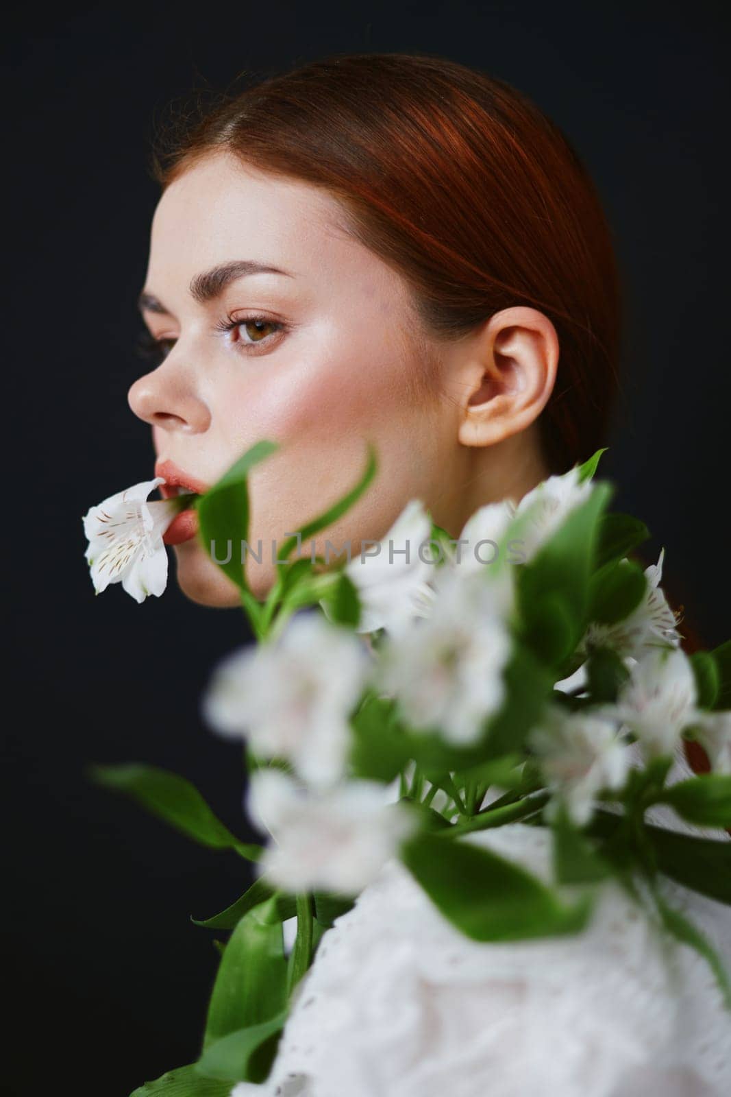 A beautiful woman, showcasing a calm demeanor, poses with white flowers against a dark backdrop This image emphasizes beauty, nature, and tranquility, ideal for health related projects