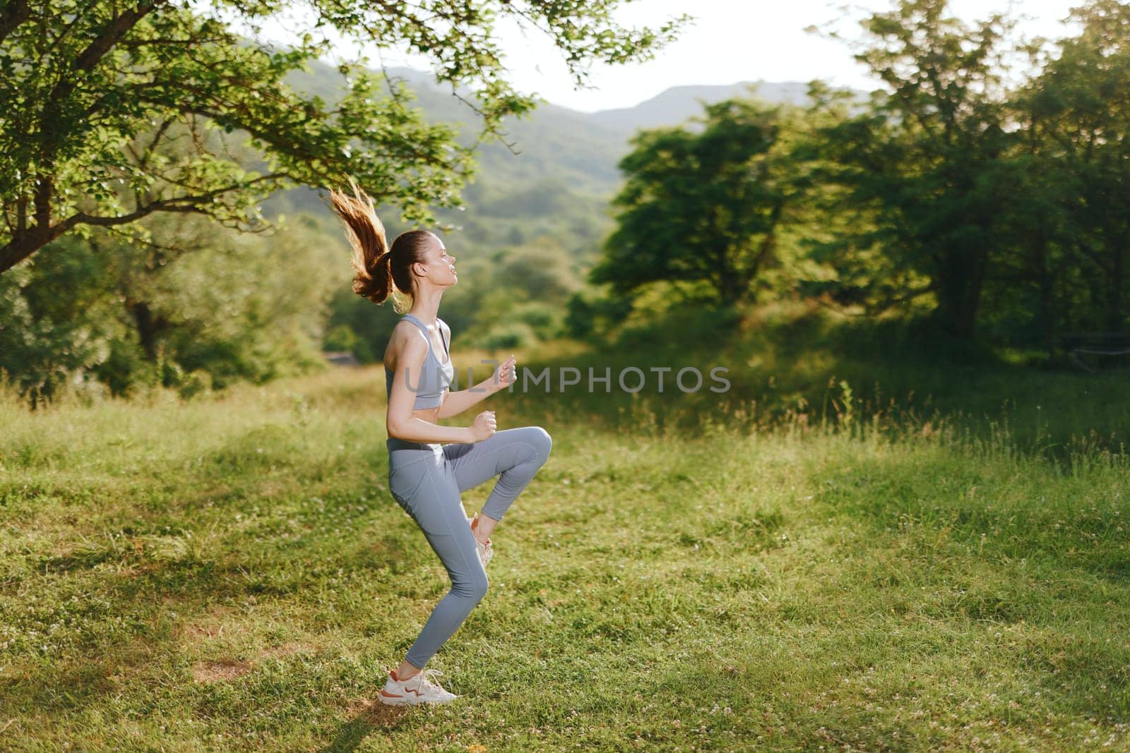 Energetic young woman in blue activewear jogging through a vibrant green landscape, expressing joy and determination Perfect for fitness, healthy lifestyle themes