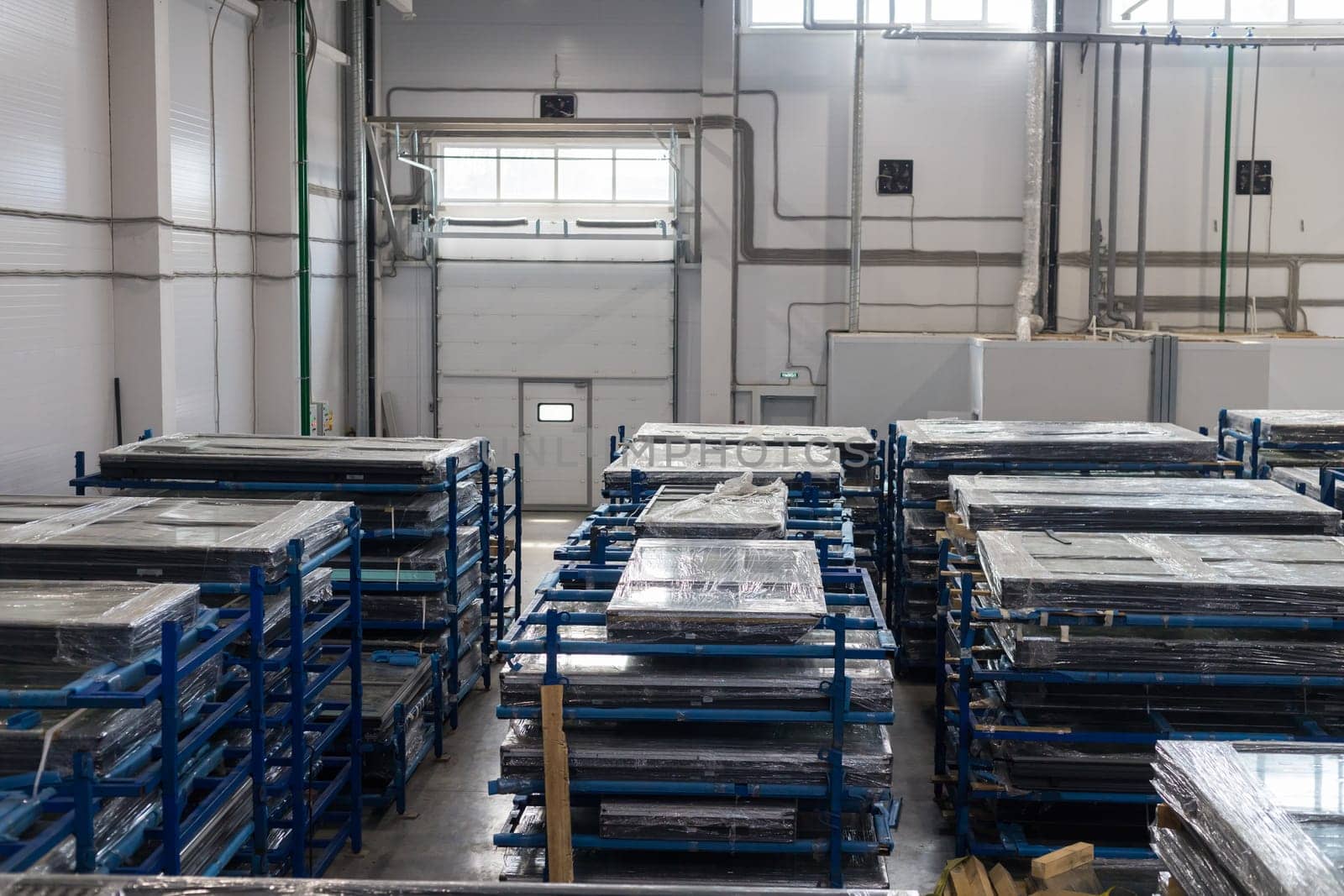 Wrapped pvc window frames are stored and ready for shipping in a large distribution warehouse