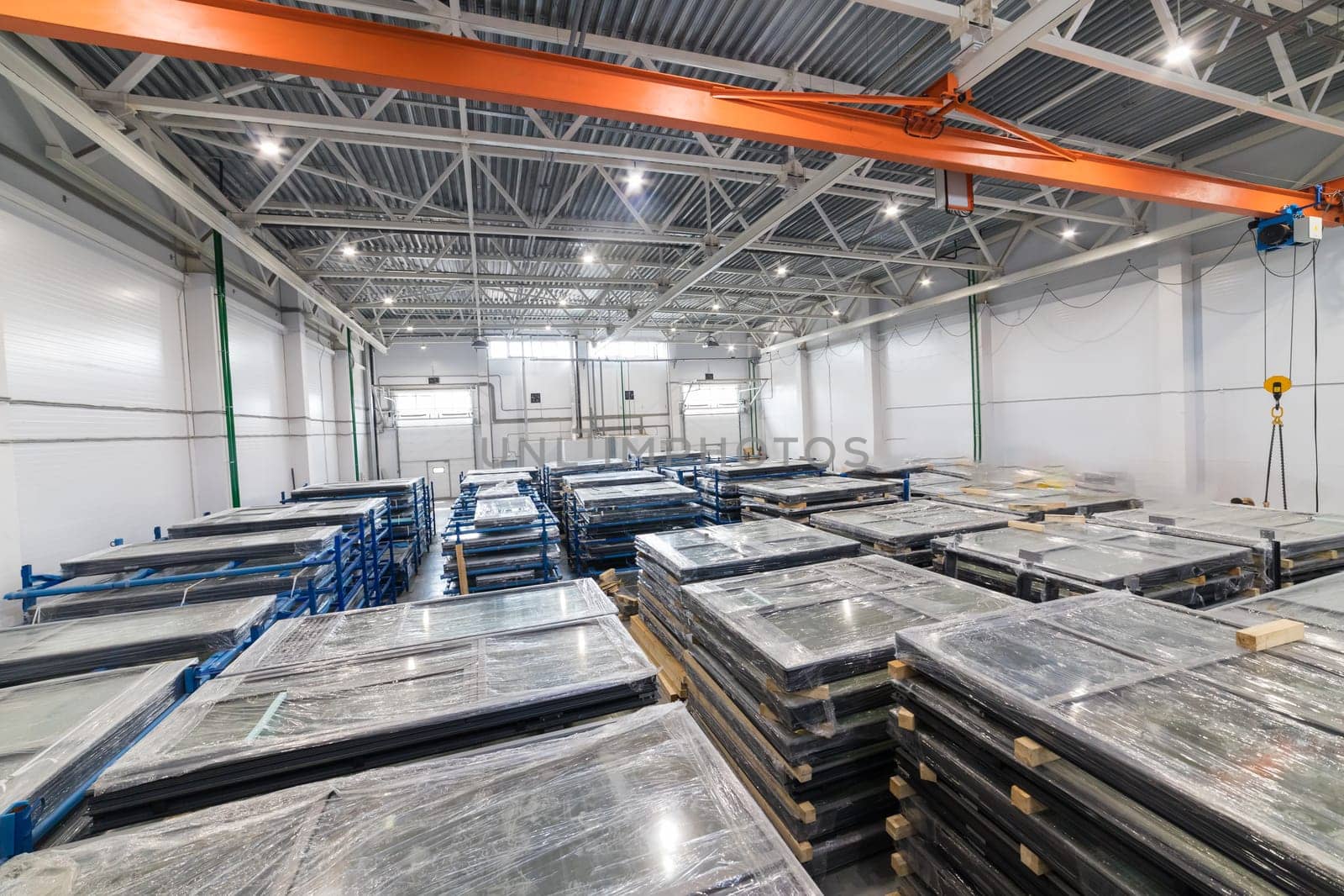 Interior of a storage warehouse with pvc windows wrapped in stretch film, placed on pallets and ready for shipping