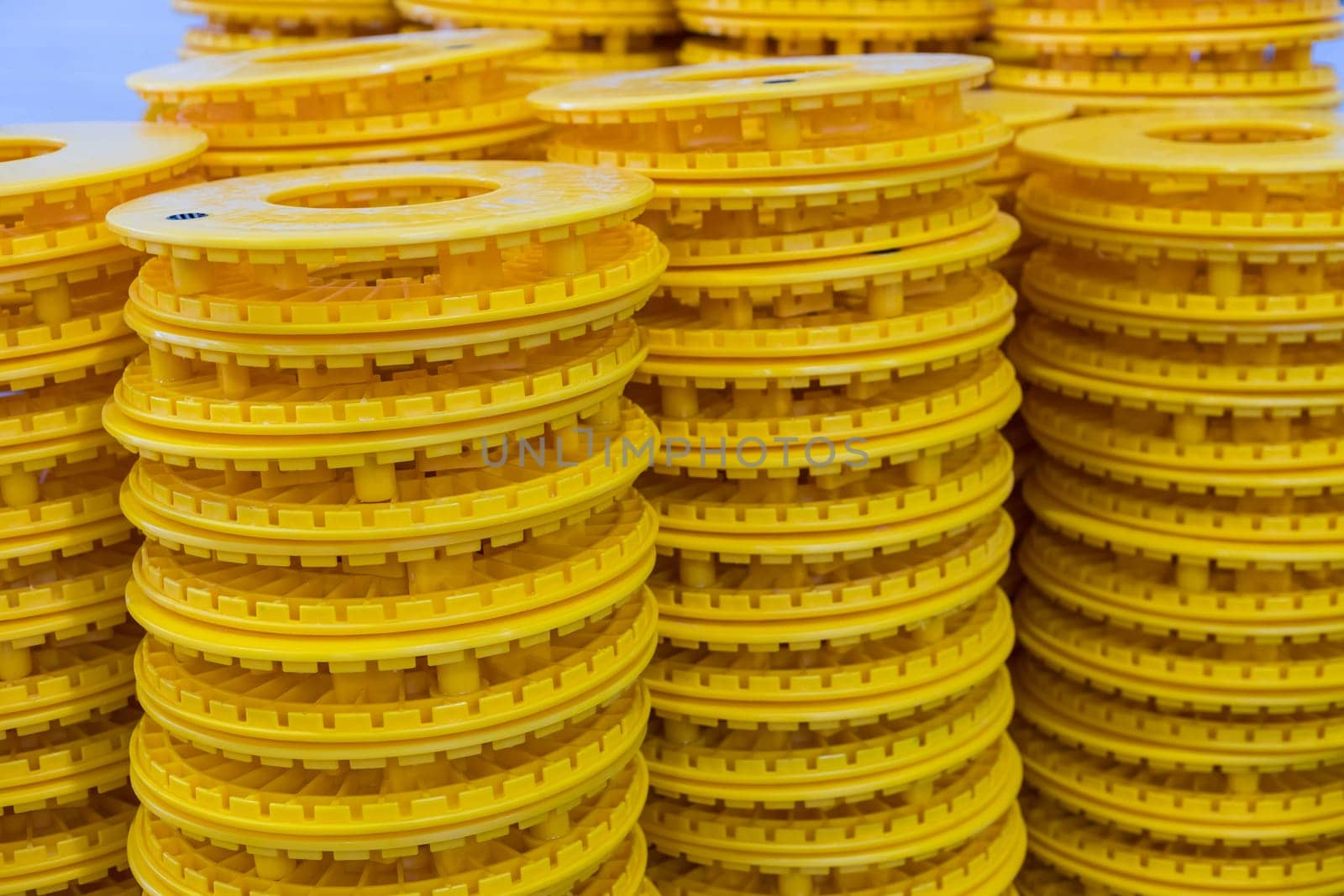 Vibrant yellow plastic rings stacked high, showcasing precision and uniformity in a manufacturing or storage setting