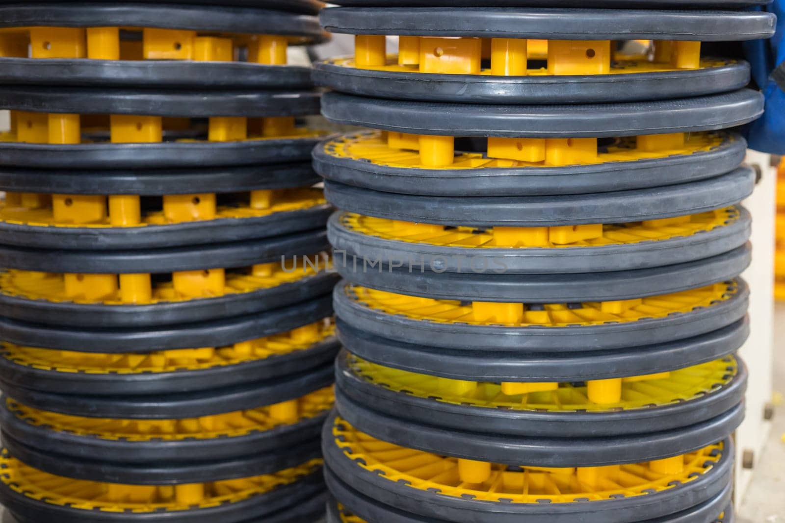 Stacks of rubber wheels with yellow plastic hubs create an industrial pattern