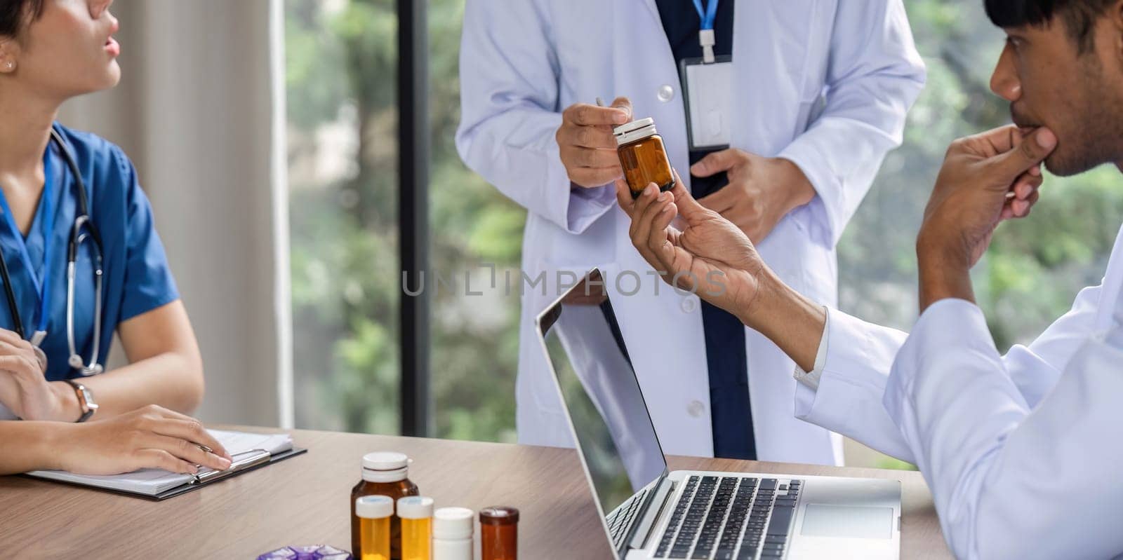 A doctor consulting with a colleague about medication options, fostering communication in a healthcare environment focused on best practices.