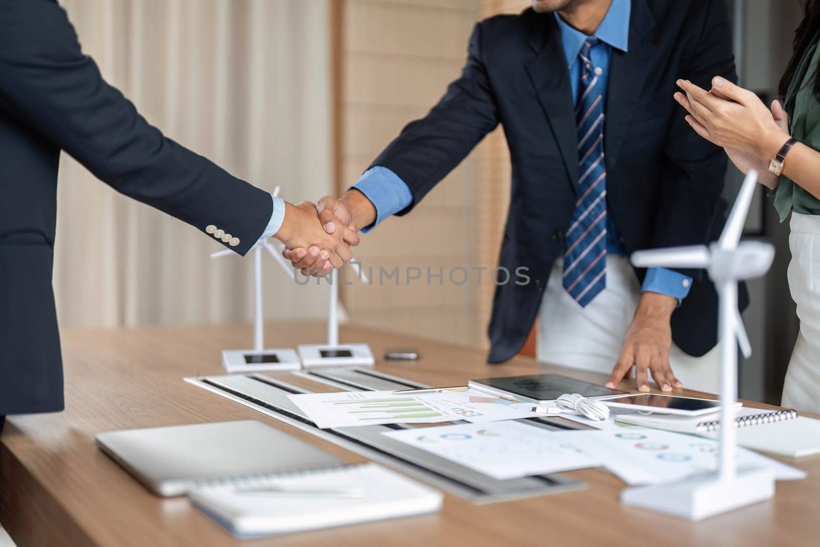 Business professionals engaging in a handshake to formalize an agreement, highlighting commitment to sustainability and collaboration in their meeting.