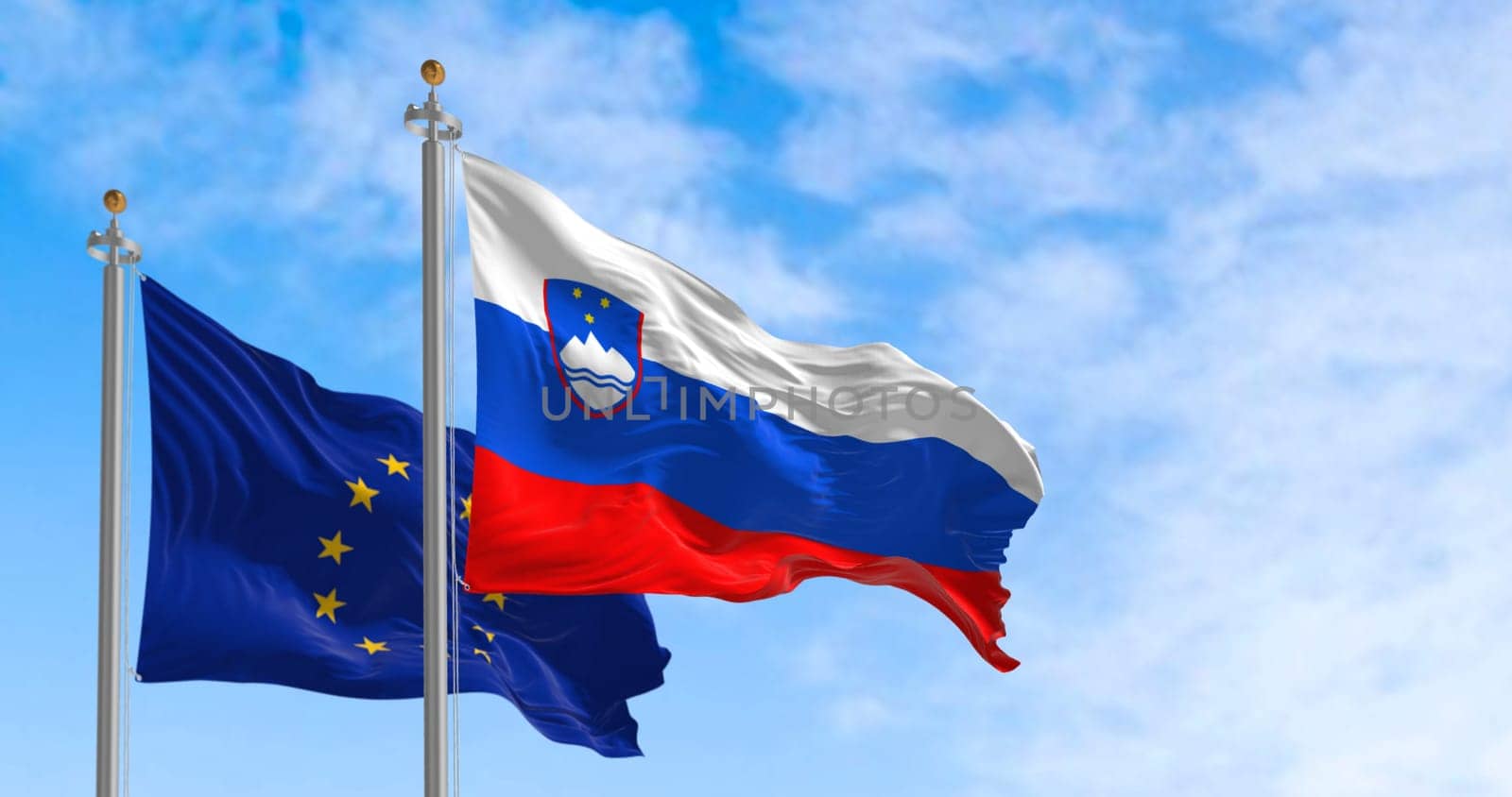The flags of Slovenia and the European Union waving in the wind on a clear day. European Union member since 2004. 3d Illustration render. Fluttering fabric.