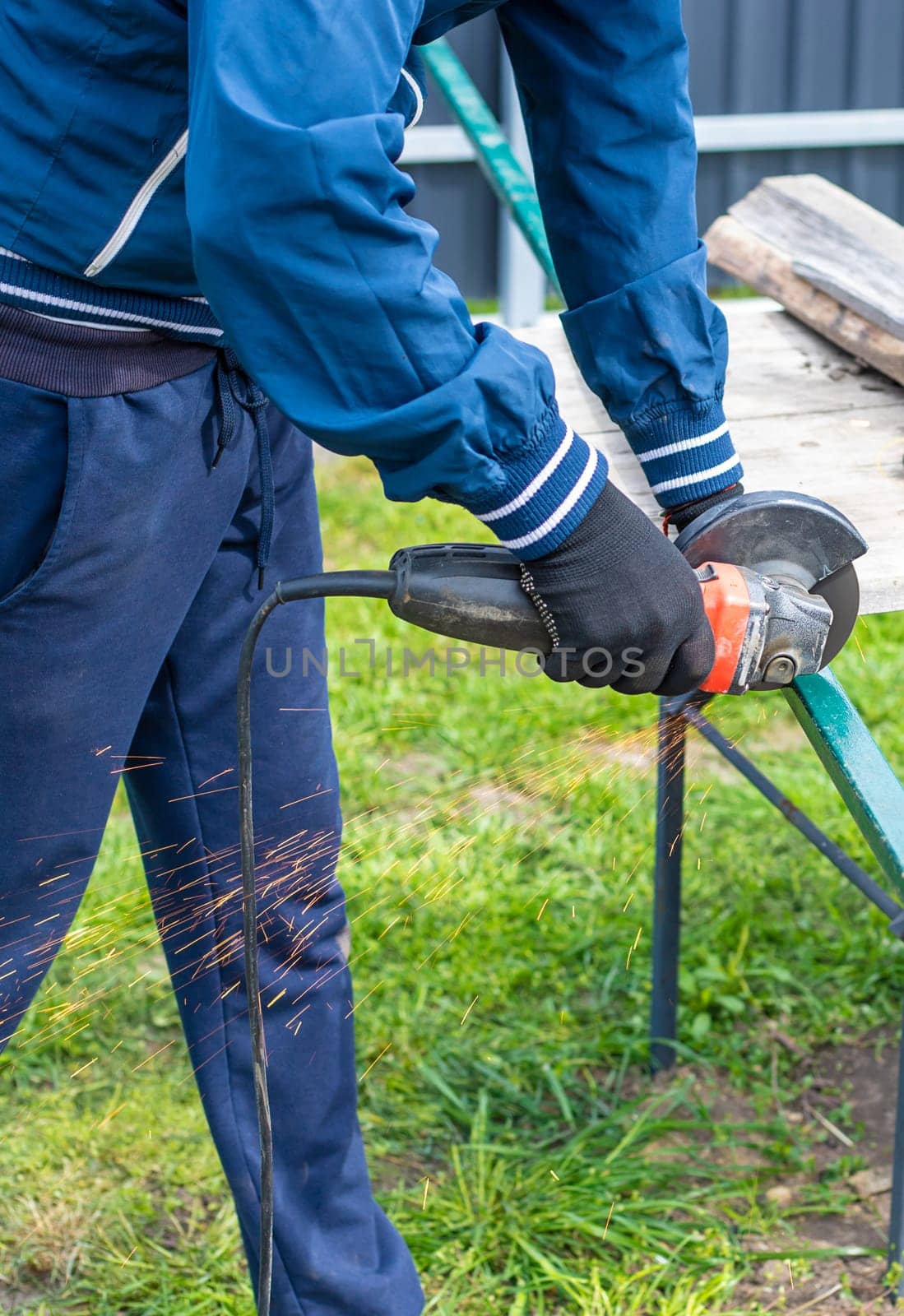 A man works with a grinder on metal. Selective focus. people.