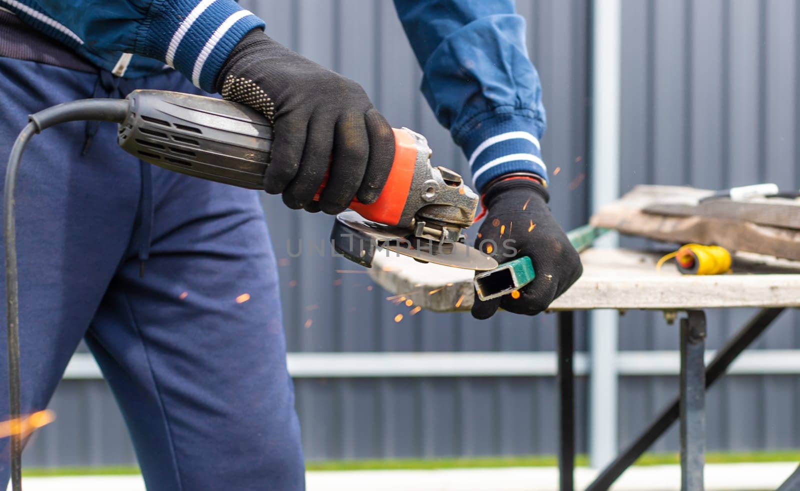 A man works with a grinder on metal. Selective focus. people.